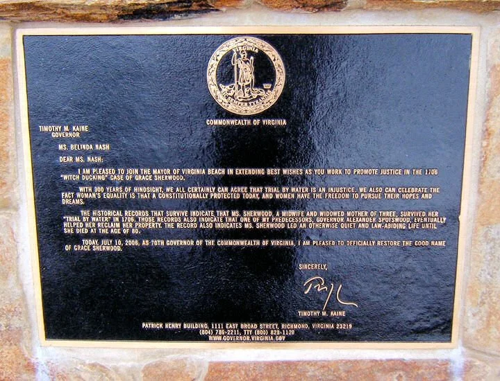 Plaque on the statue "restoring the name" of the alleged Witch of Pungo