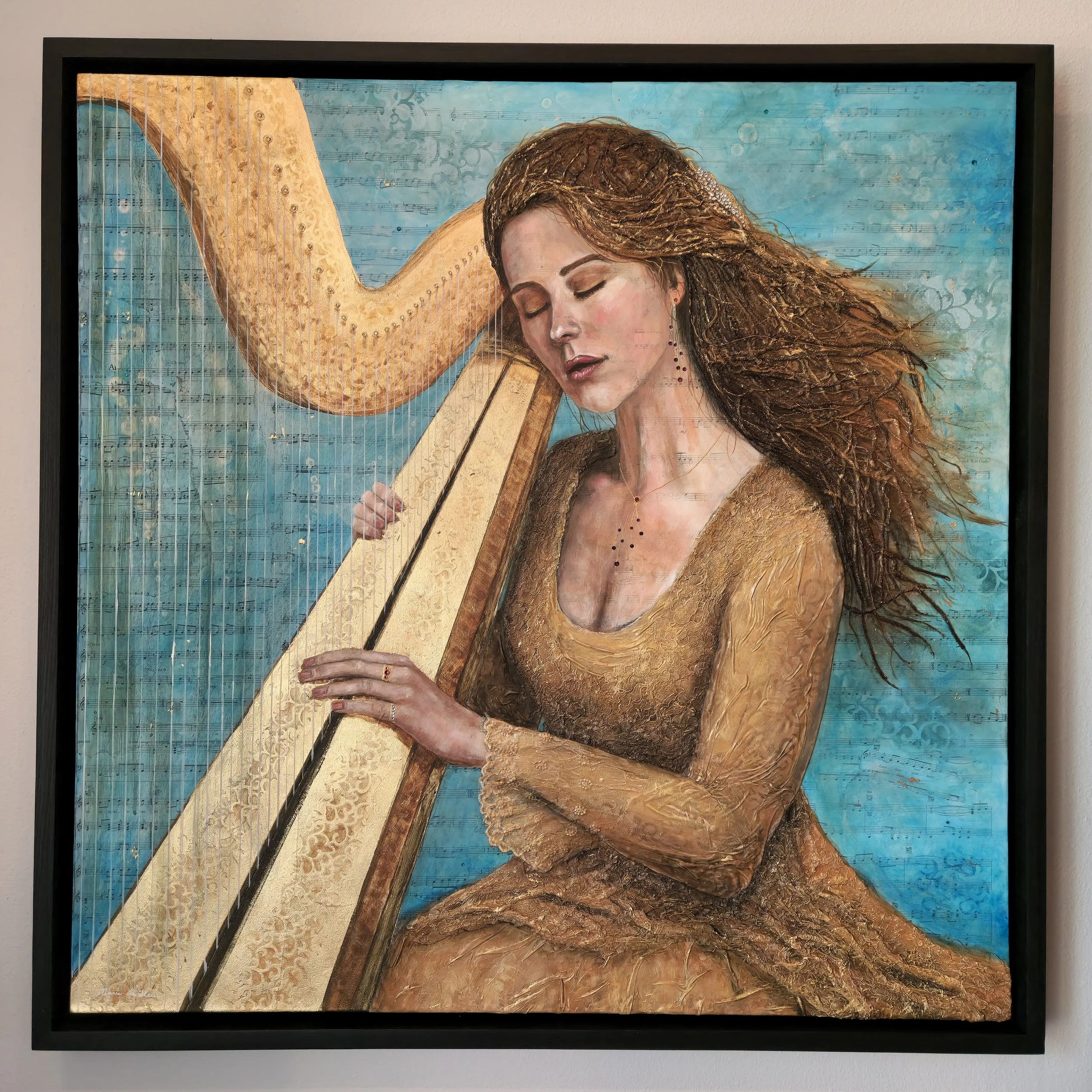 Woman in a golden lace dress playing a harp. Her hair is gently blowing in an unseen breeze. Her eyes are closed. Painted on music sheets, done with gold highlights, lace, crystals, heavy texture. Framed in a handmade wooden frame and ready to hang.