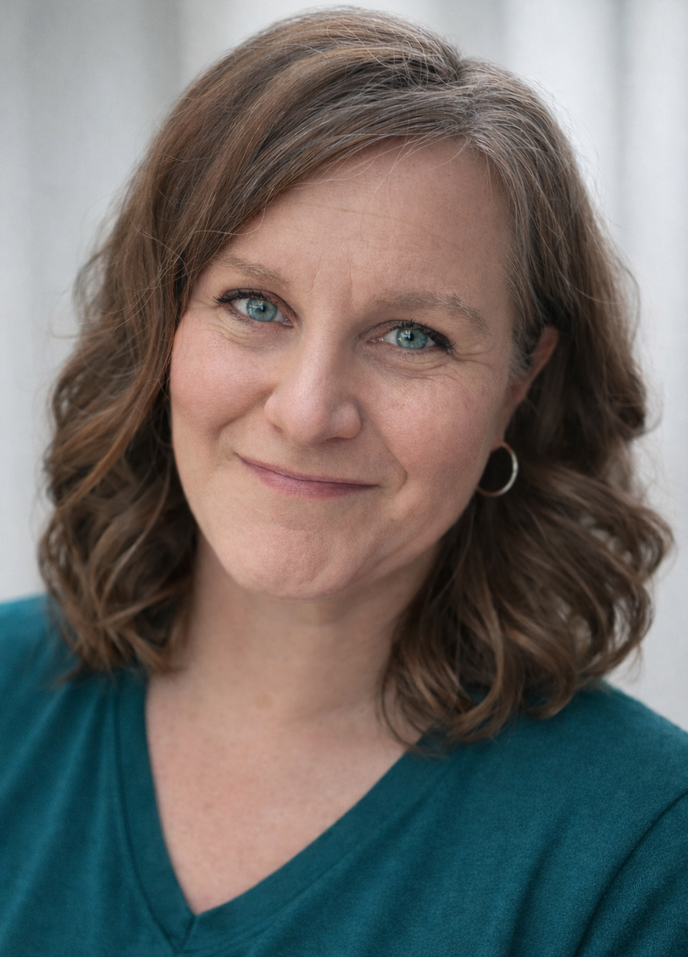 This is a photo of the owner of Carys Counseling & Consulting from the shoulders up, with shoulder length wavy hair and smiling.