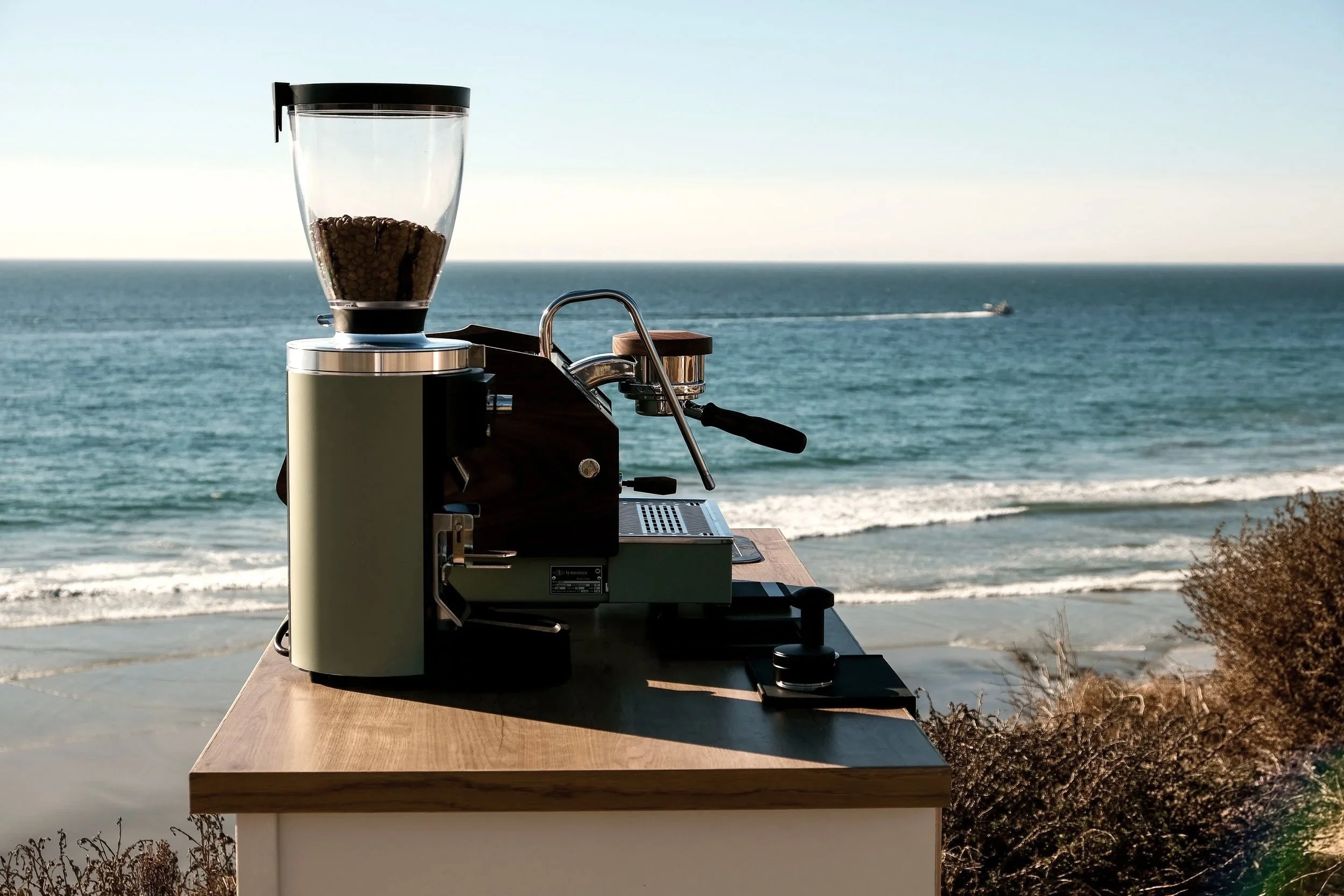 photo of espresso machine and grinder by the ocean