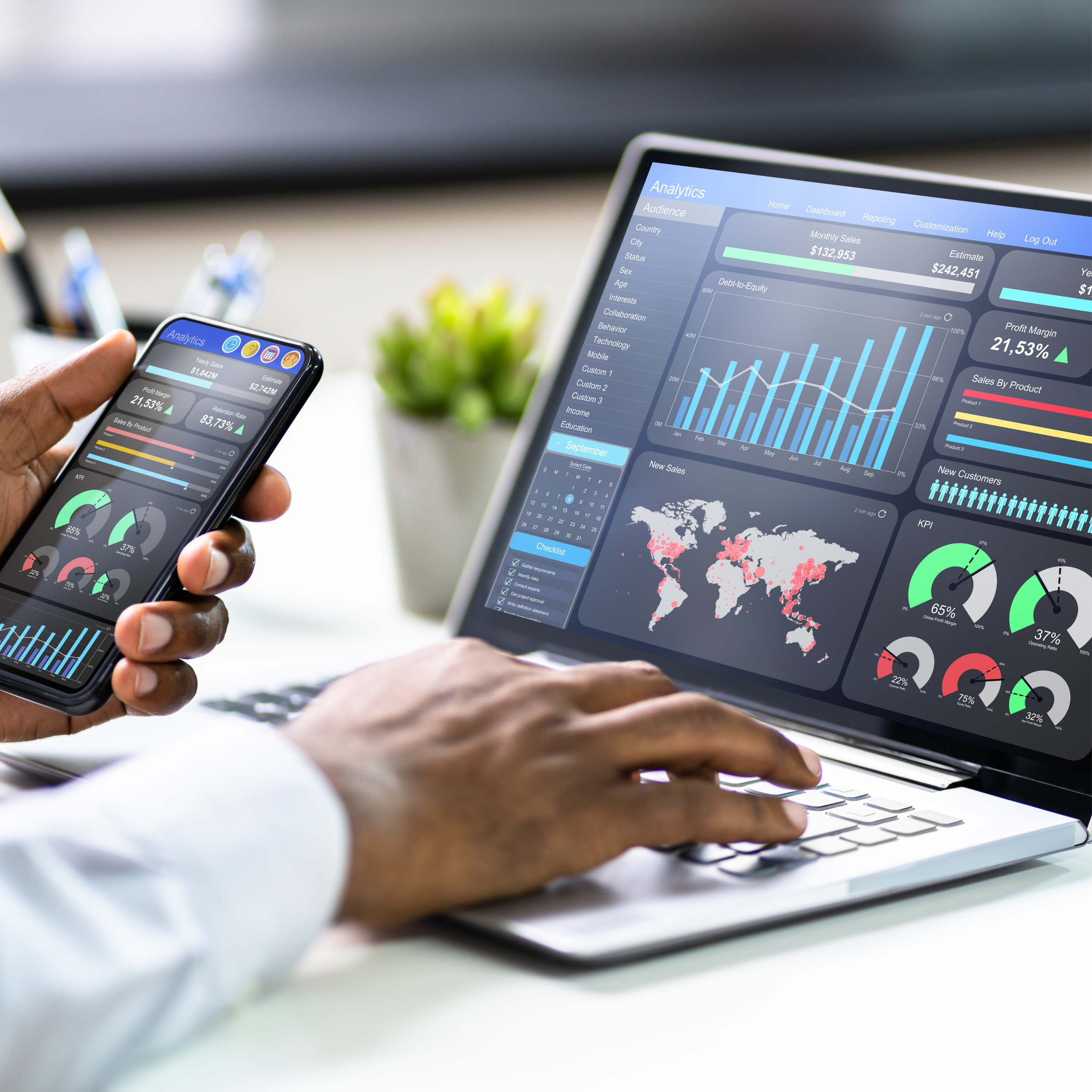 Person viewing business analytics on a laptop and smartphone, showing charts, graphs, and world maps.