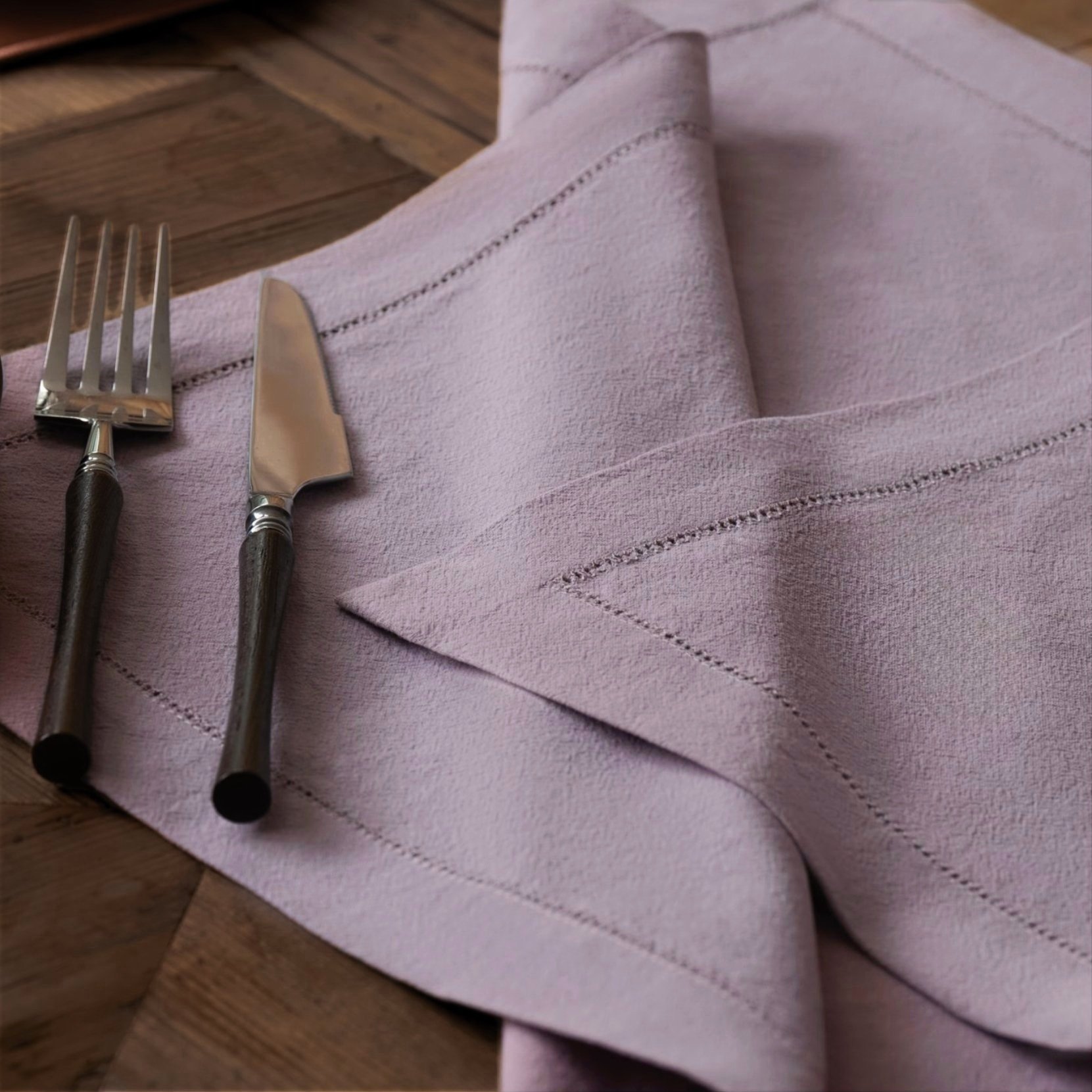 Hemstitch embroidered purple cotton napkin casual spread on a wooden table