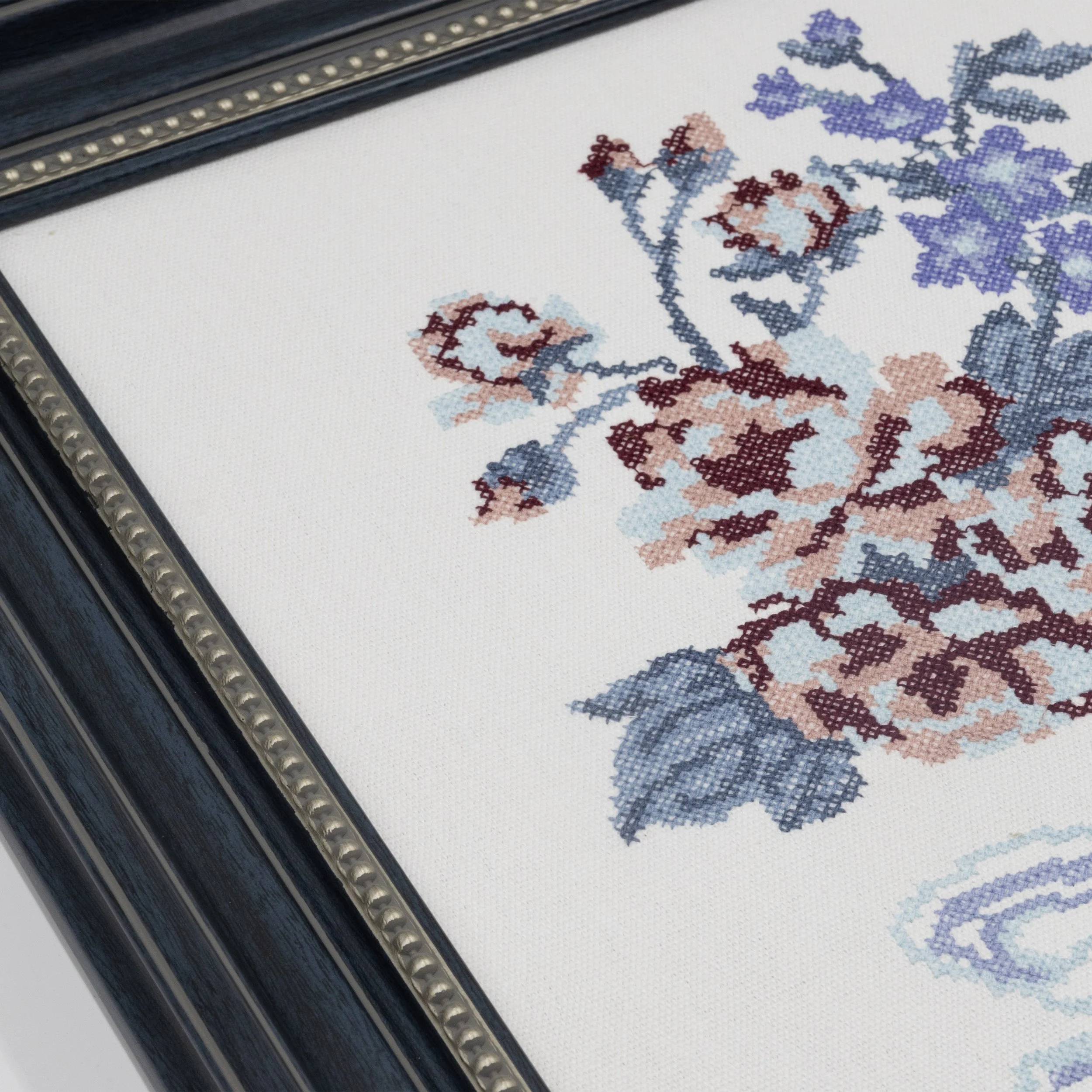 Close-up of Bouquet cross stitch embroidery showing floral details and textured stitching on cotton fabric