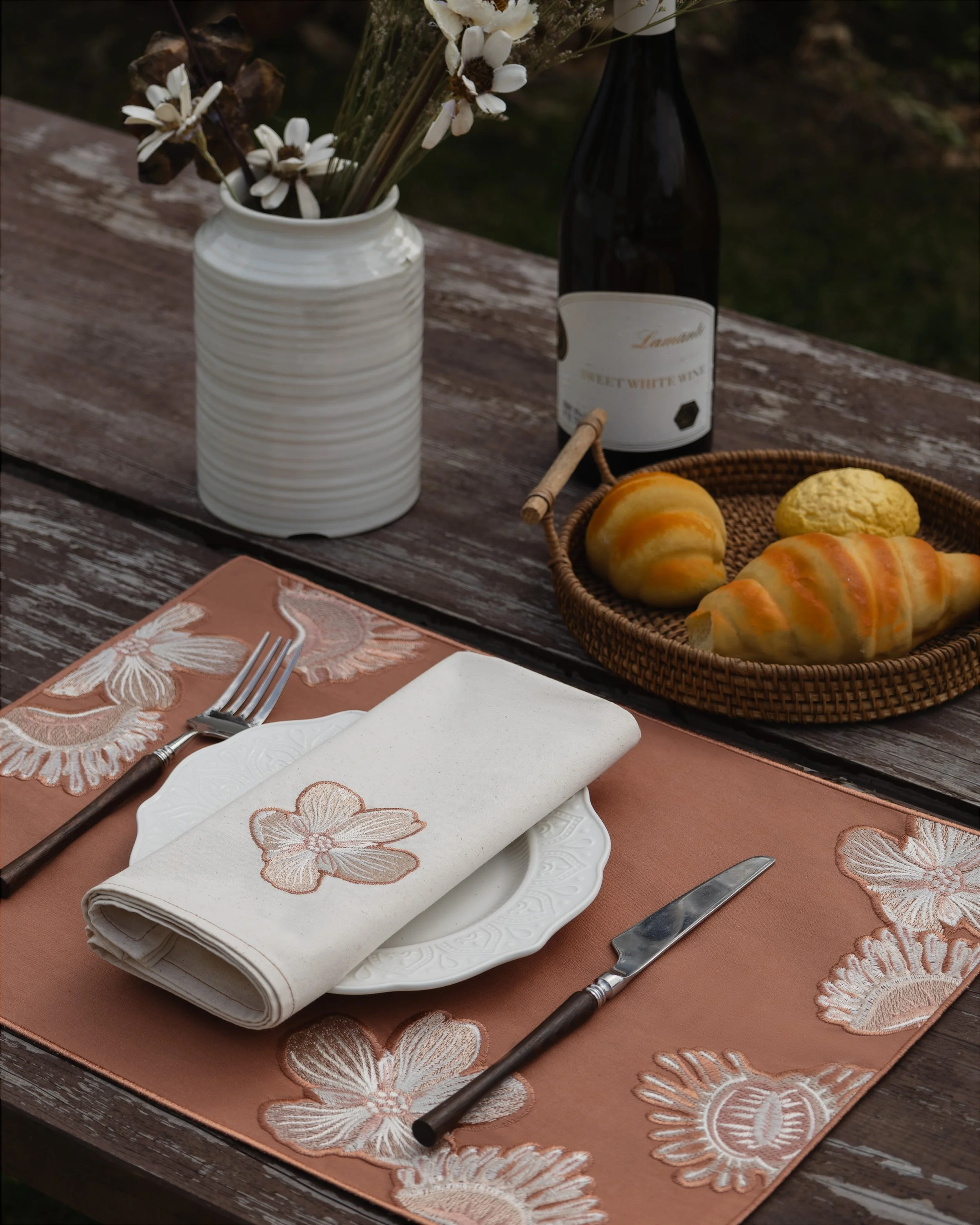 Dionaea series embroidered napkin and placemat on an outdoor table.jpg
