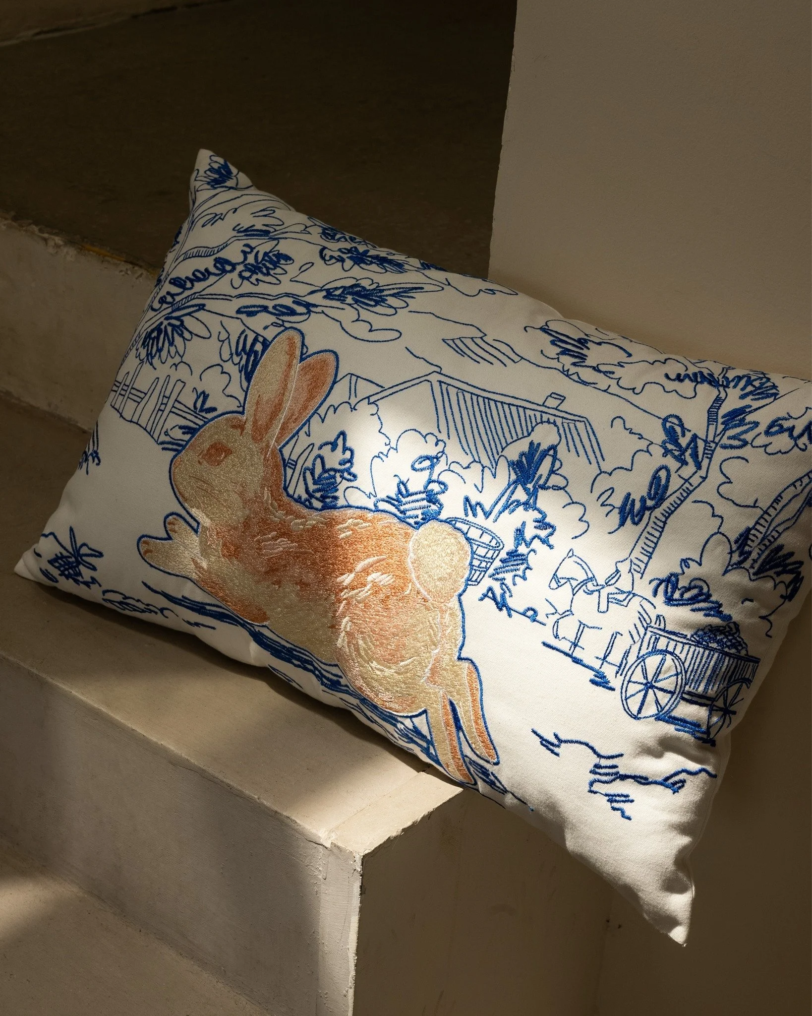 If you like a softer, quieter corner, the Whimsy lumbar pillow fits in easily.

The rabbit feels calm and a little playful, and the blue linework keeps the whole piece light, so it doesn&rsquo;t weigh the space down.

In sunlight, the embroidery pick