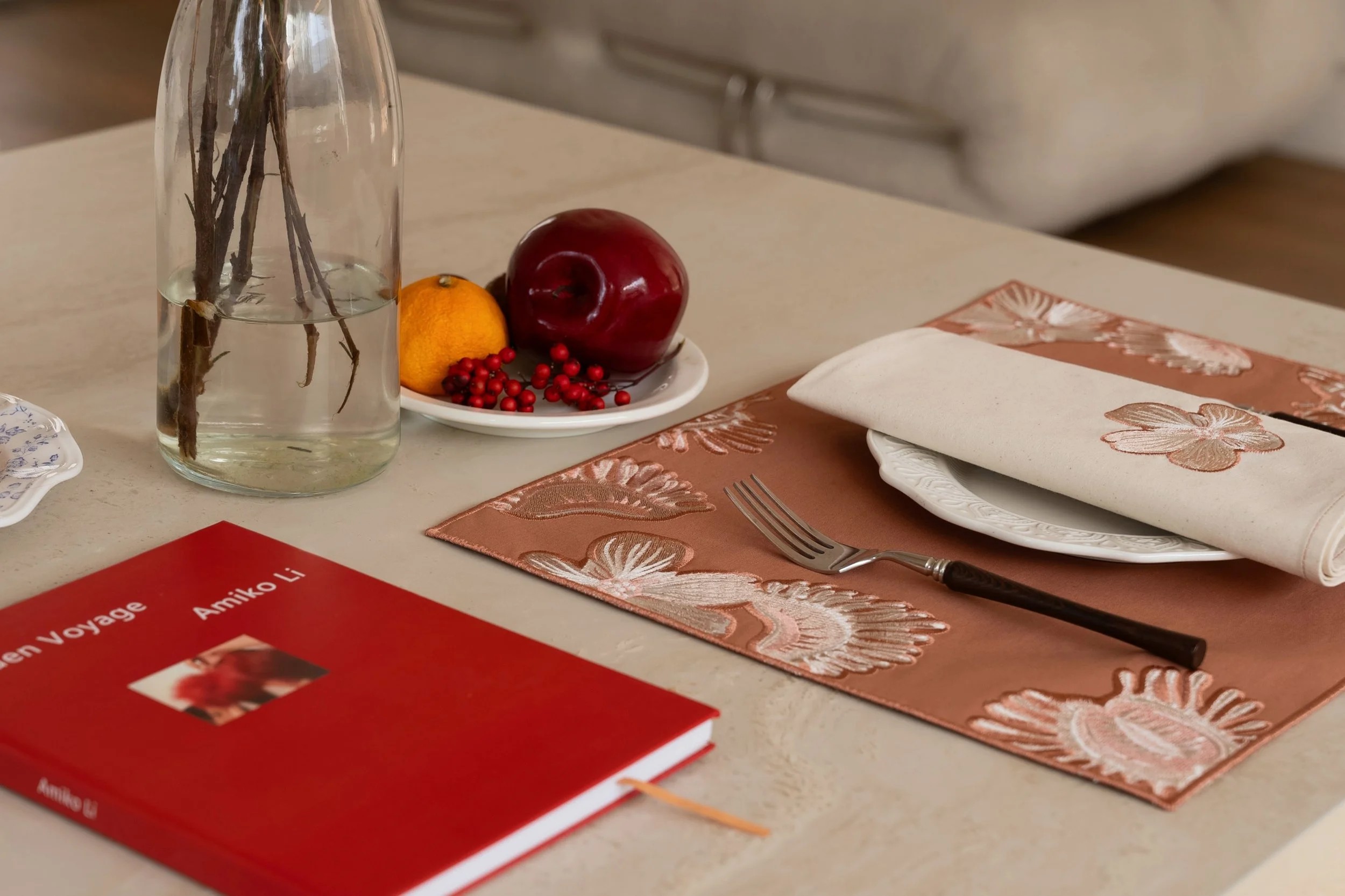 venus flytrap embroidery placemat and napkin on dining table with botanical textile design and terracotta tones