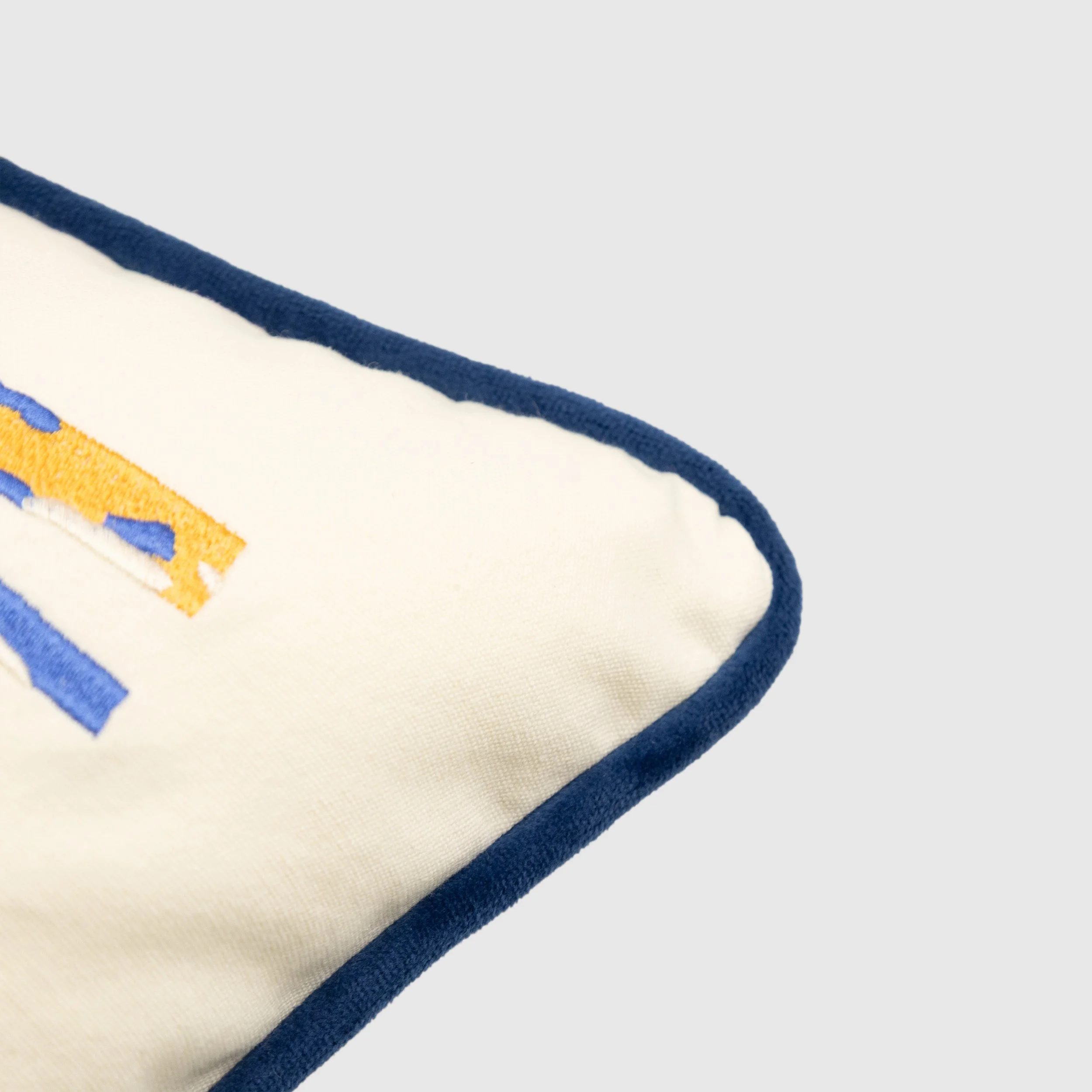 Close-up of blue piping and embroidered cotton fabric on winter forest throw pillow