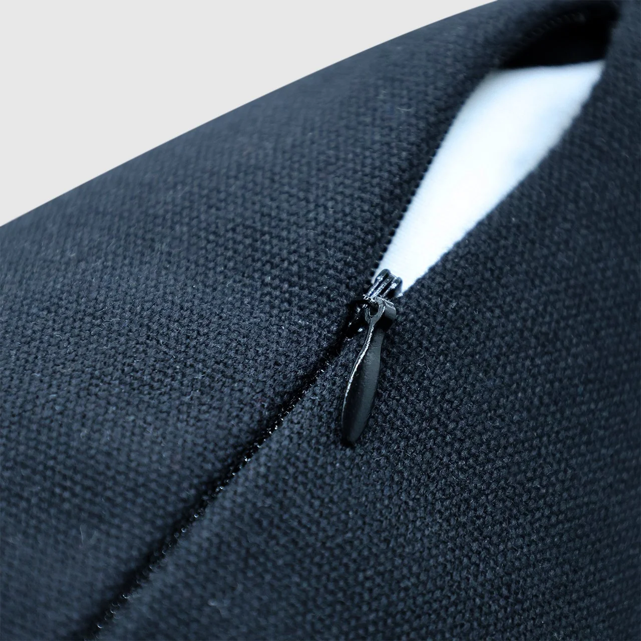 Close-up view of the invisible zipper on the black embroidered Etherelle throw pillow cover.