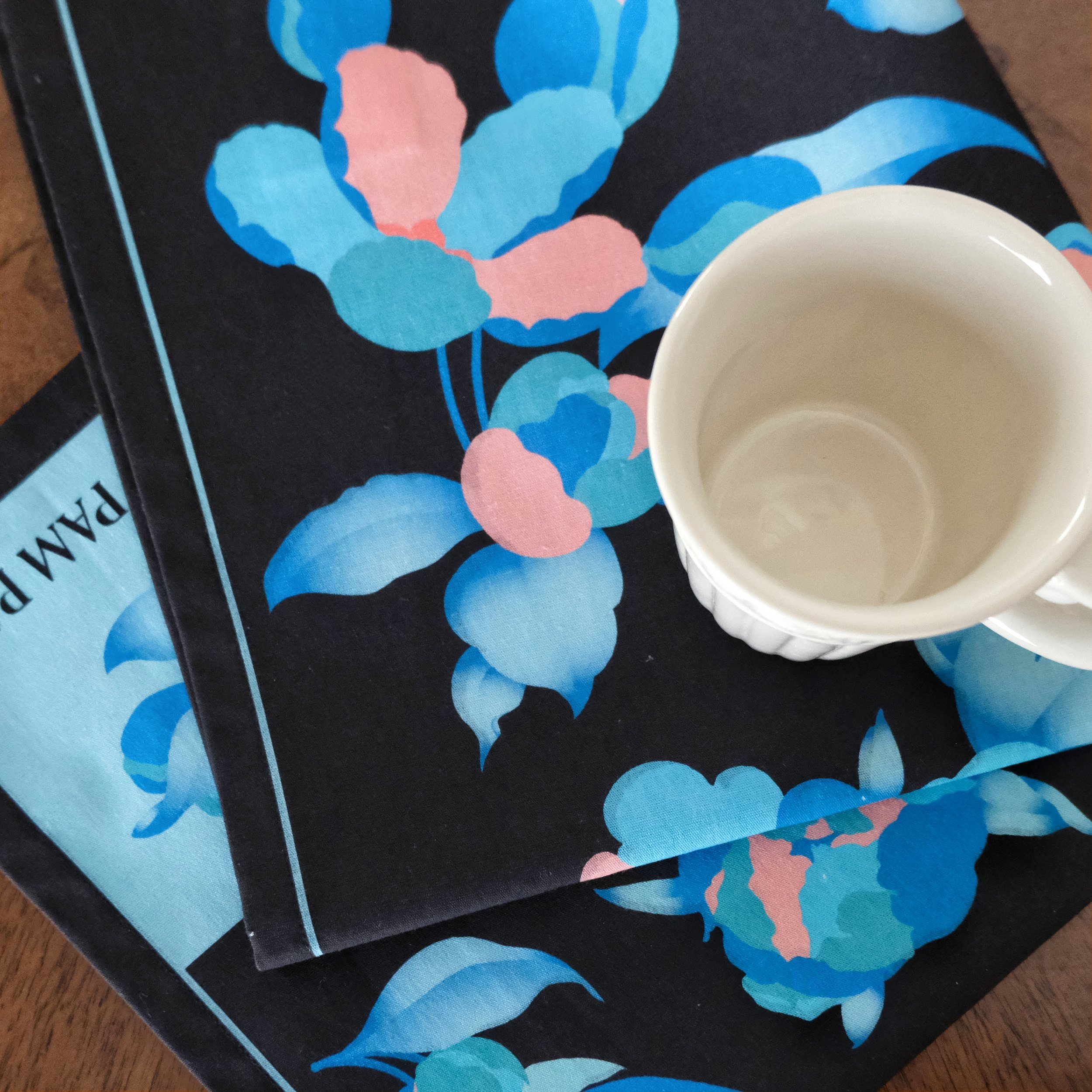 Casual Fold of Blue Flower Printed Napkin on a Wooden Table with a White Coffee Mug