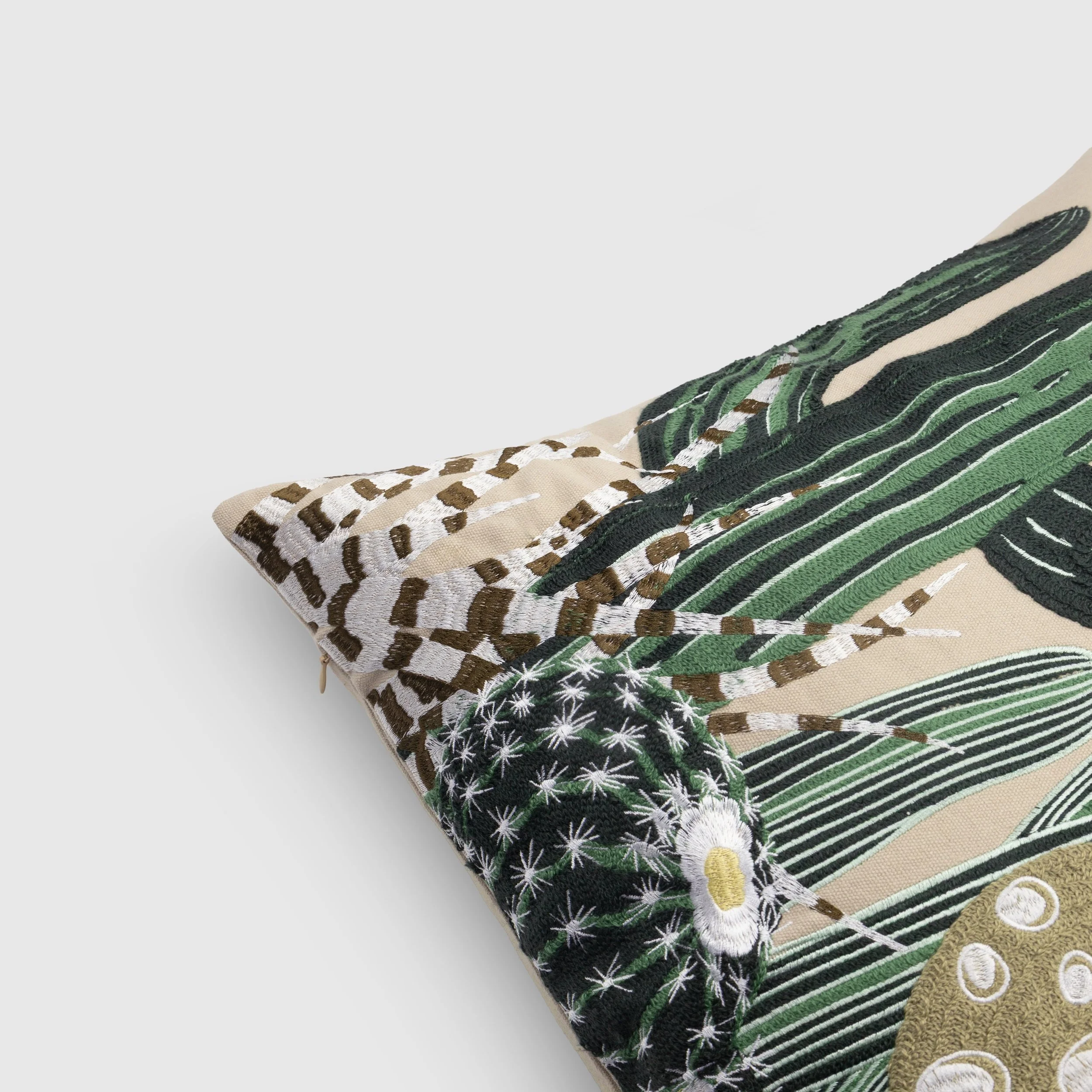Close-up detail of embroidery on the Arid throw pillow showing layered cactus textures and stitching