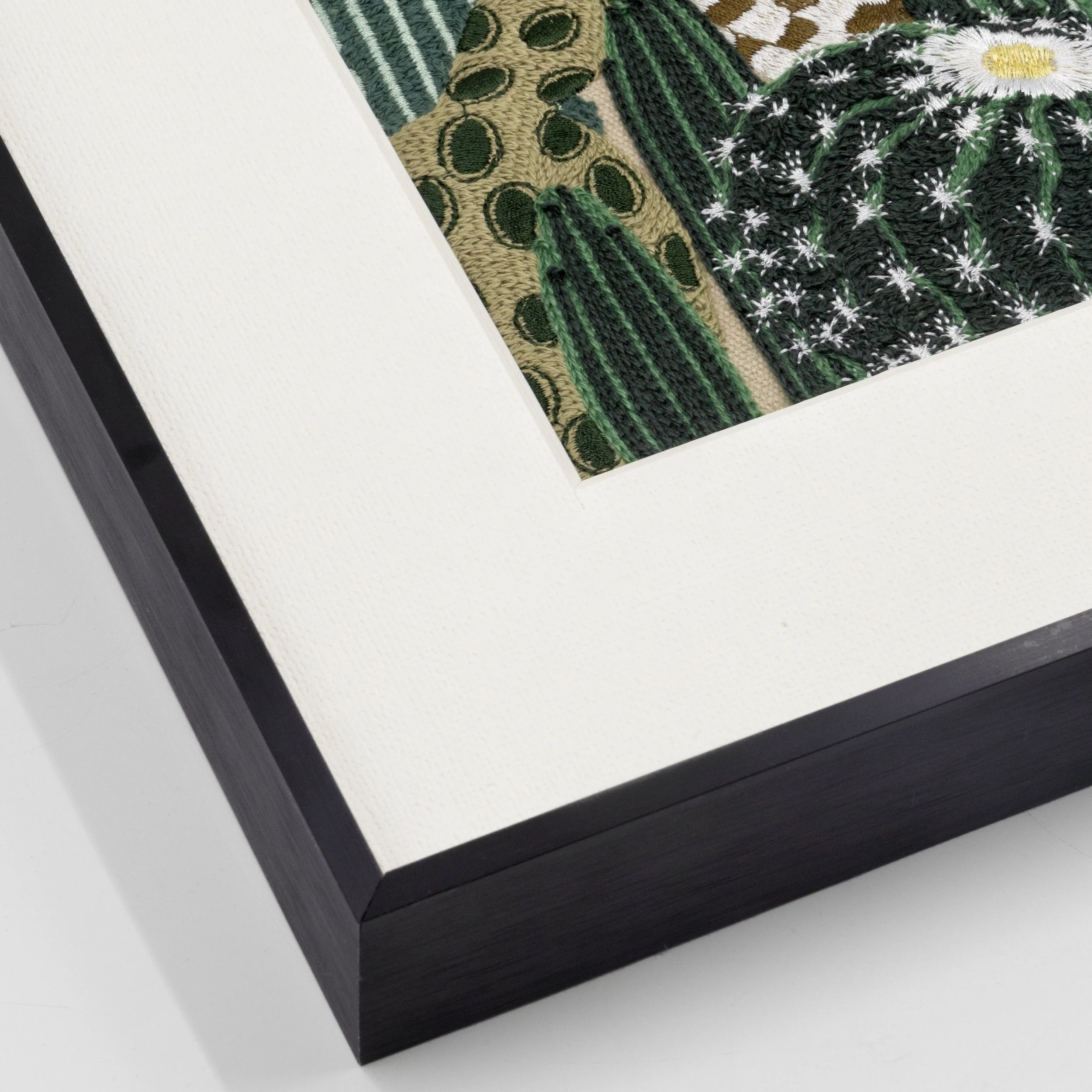 Black aluminum frame detail of the Arid embroidered wall art