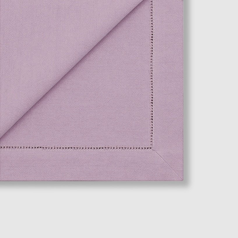 The mitered corner detail of purple cotton hemstitched napkin