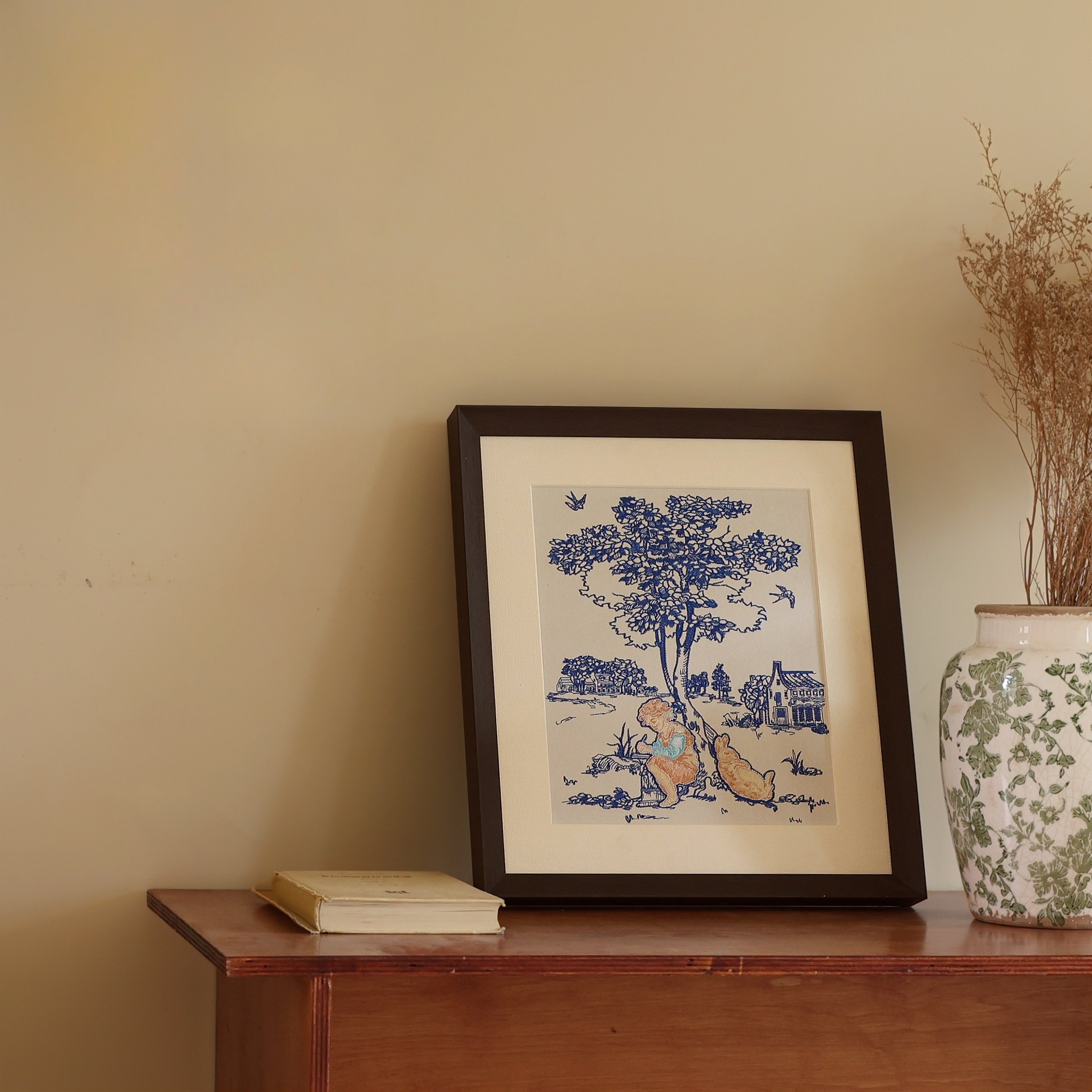 Whimsy collection embroidery wall art placed on a brown wooden counter