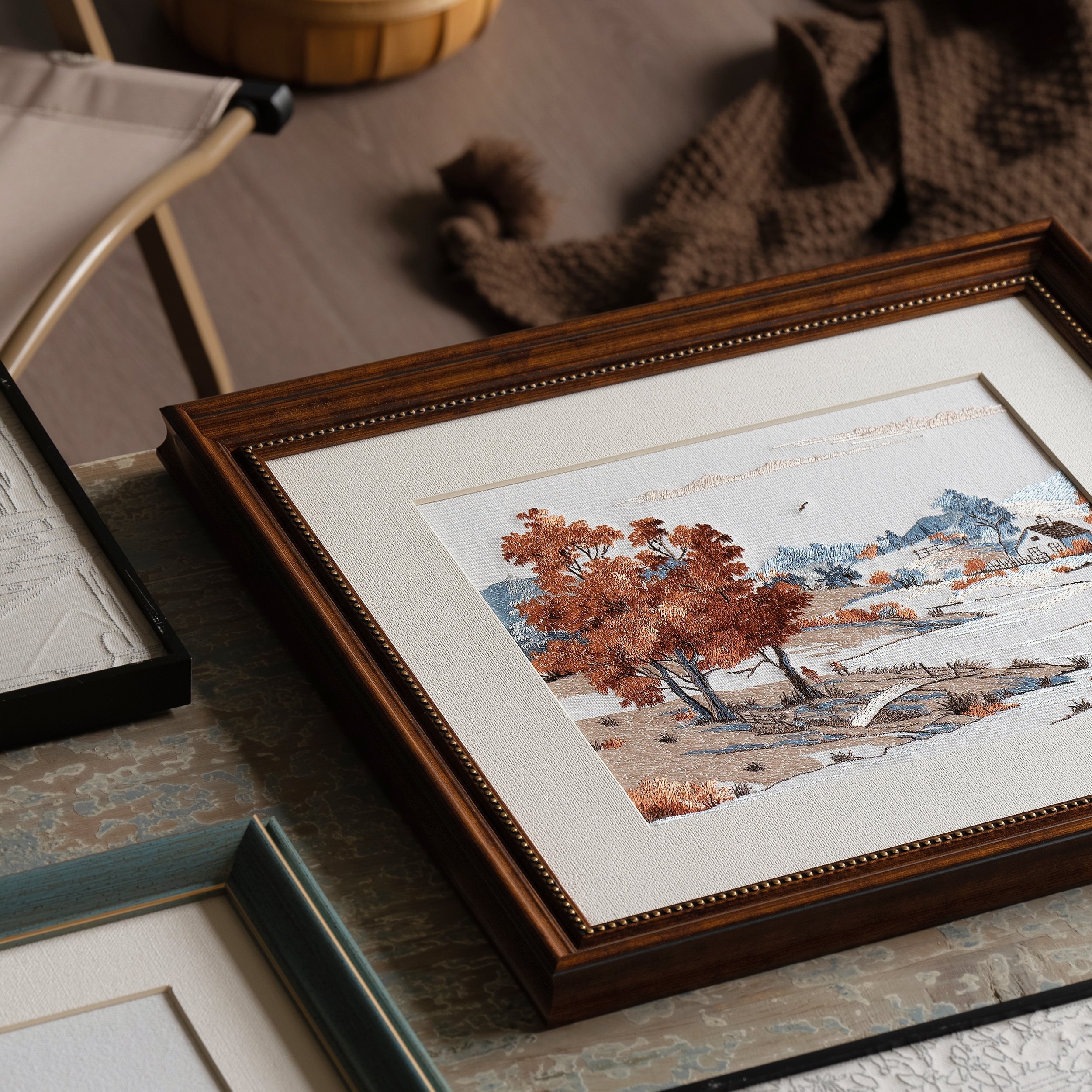 Autumn embroidered art in vintage brown frame on a wooden table