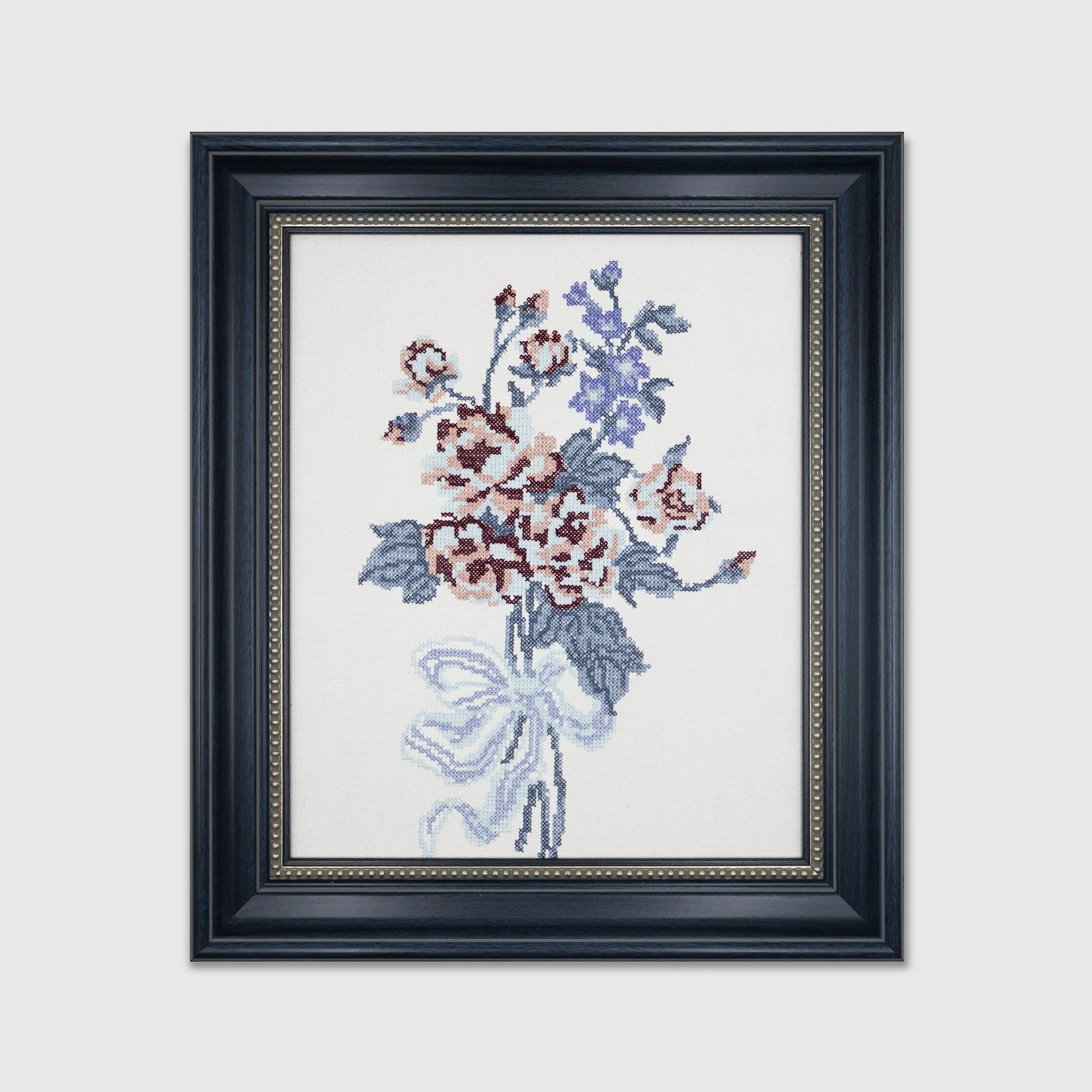 Bouquet cross stitch embroidered wall art featuring blue and blush floral embroidery in a navy frame