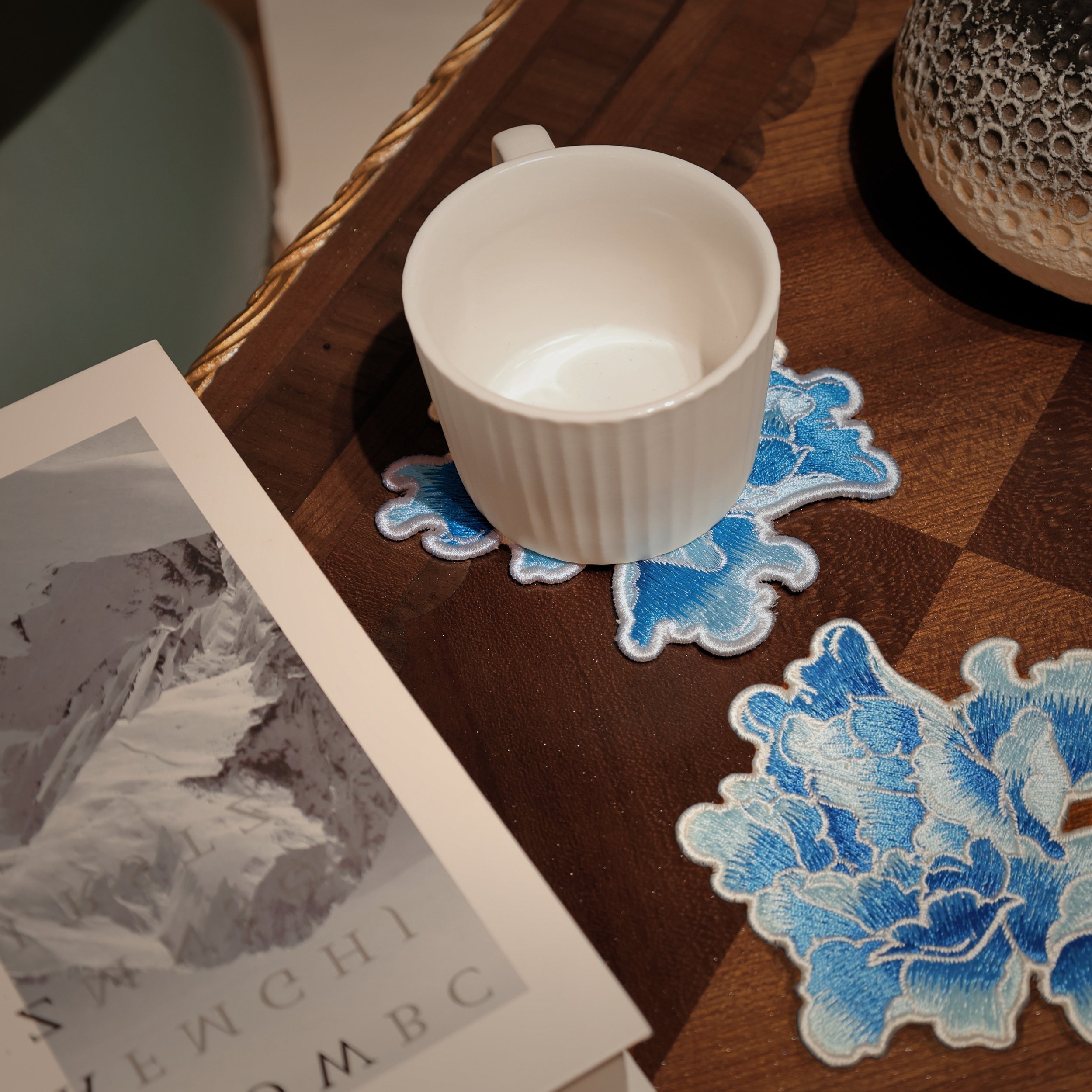 Blue floral Embroidery coasters on a vintage table with a white coffee mug
