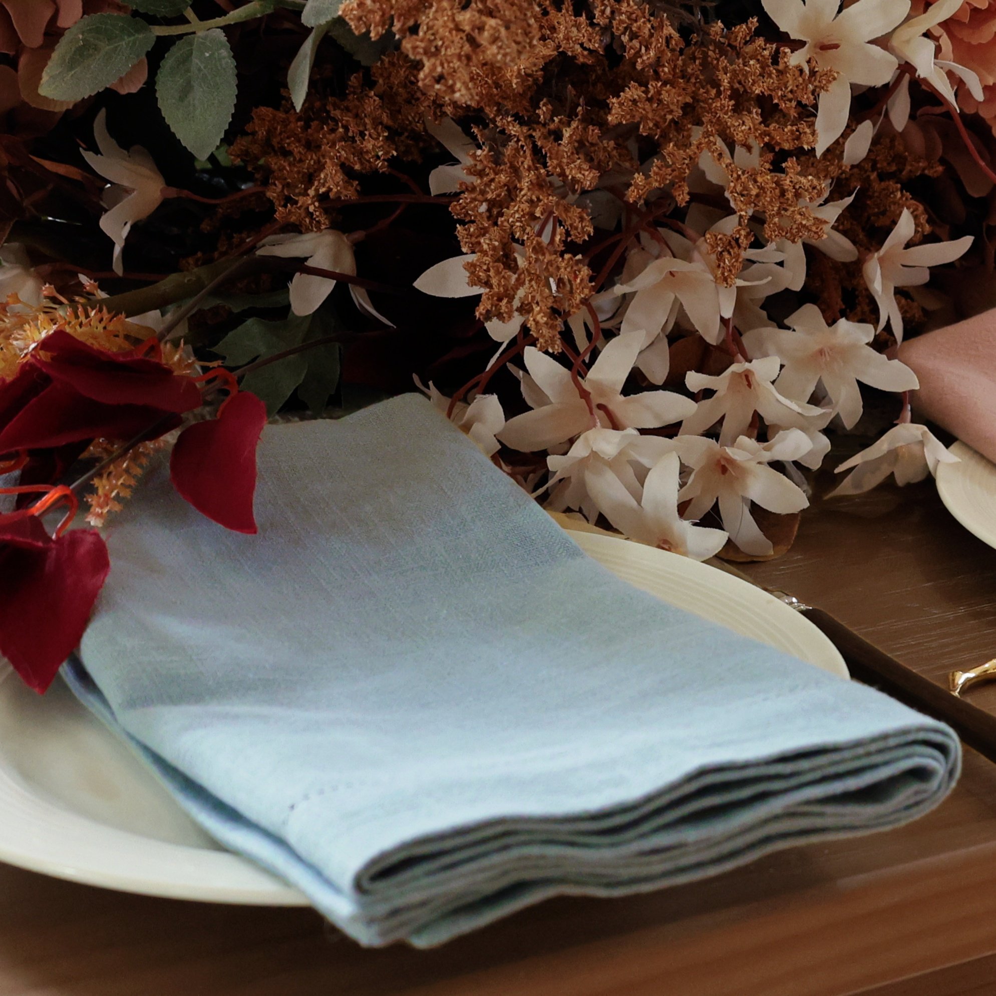 Hemstitched soft blue napkin in 1/6 fold on the wedding table
