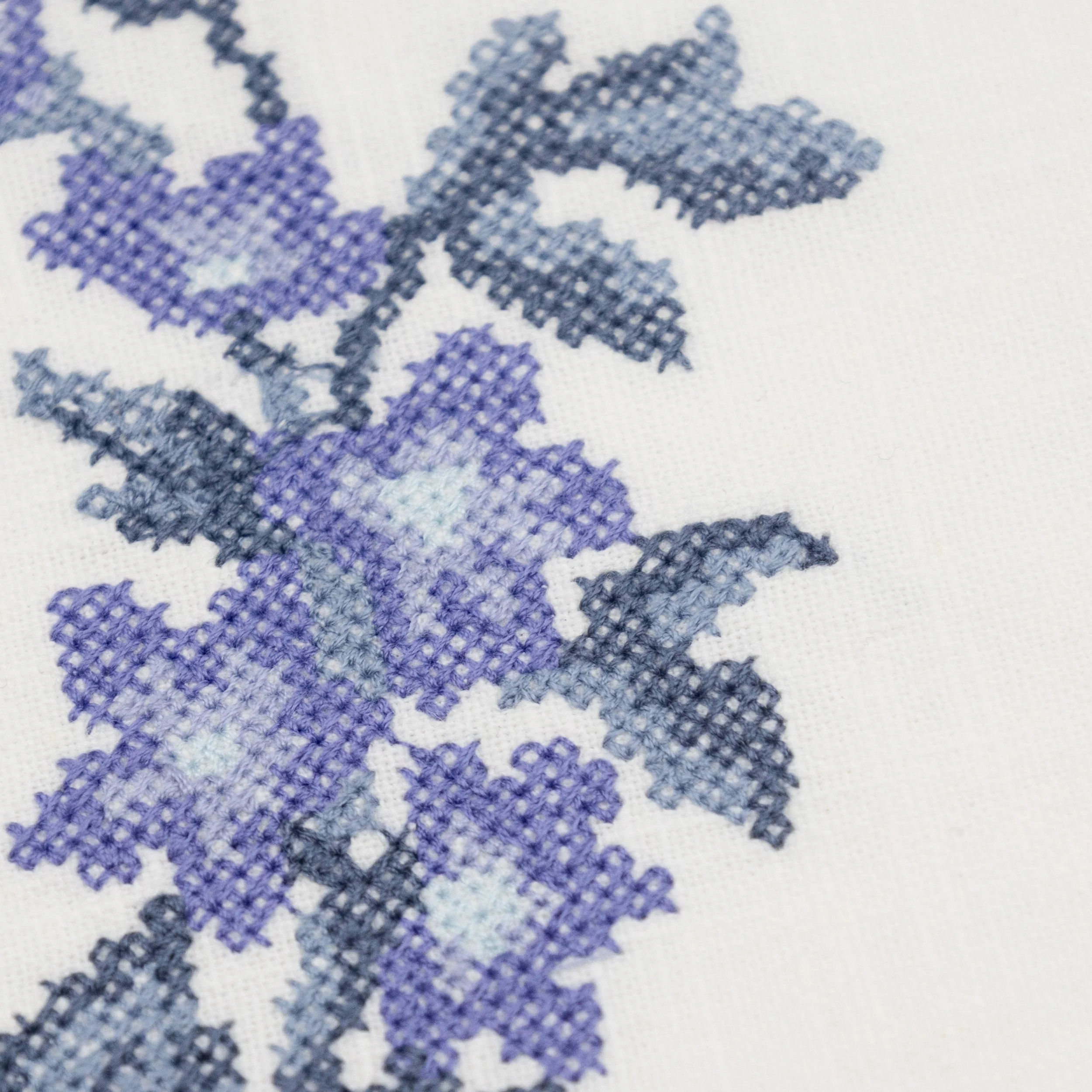 Close-up detail of lavender cross stitch floral embroidery on the Bouquet coaster