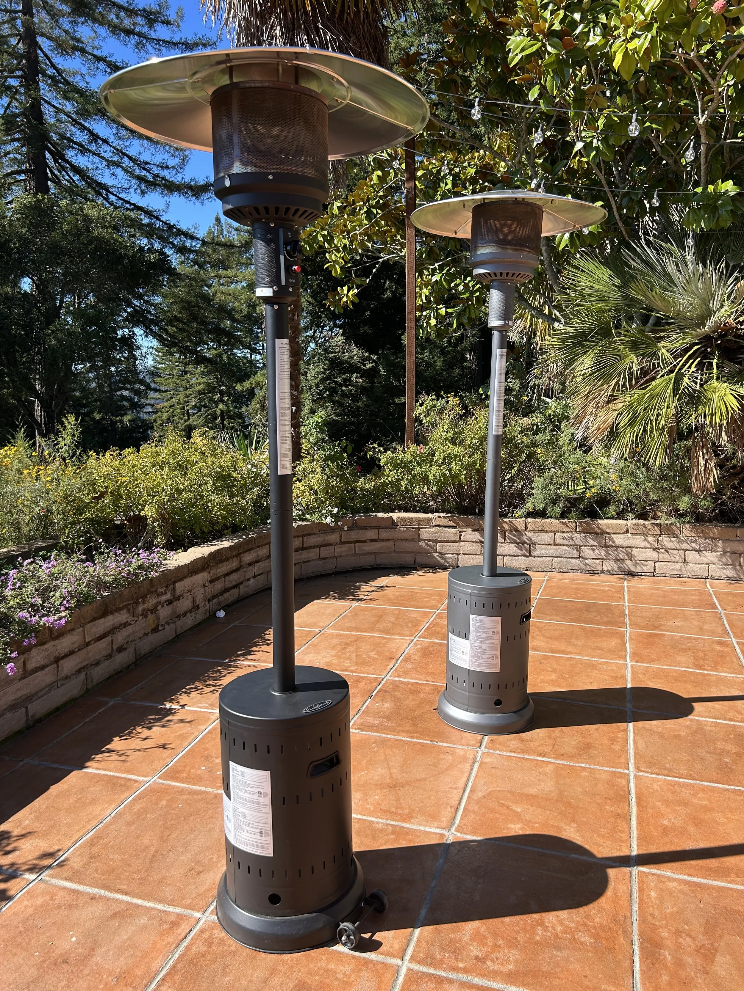 Two propane patio heaters on a tiled patio at an outdoor event