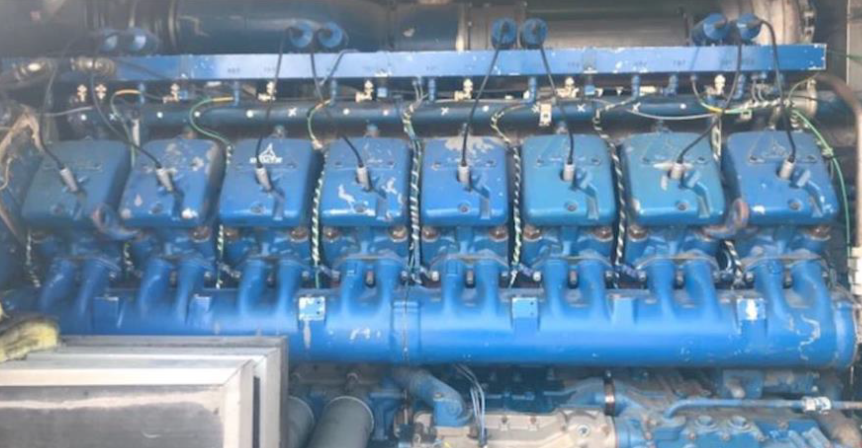 Blue industrial diesel engine with multiple cylinders and visible wiring