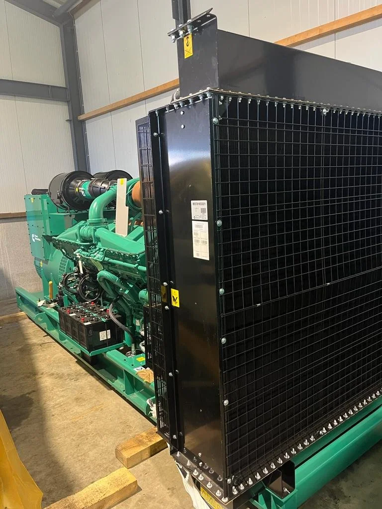 Commercial generator system inside a warehouse with green and black components.