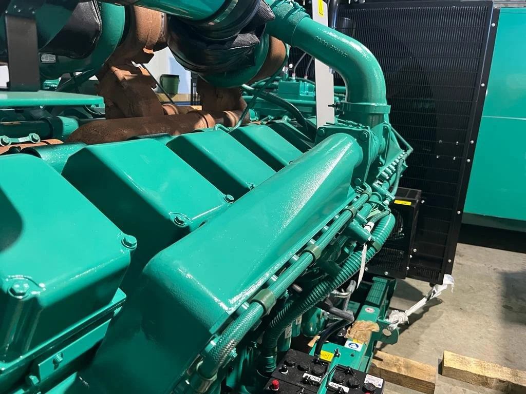 Close-up of a large industrial diesel engine with turquoise components.