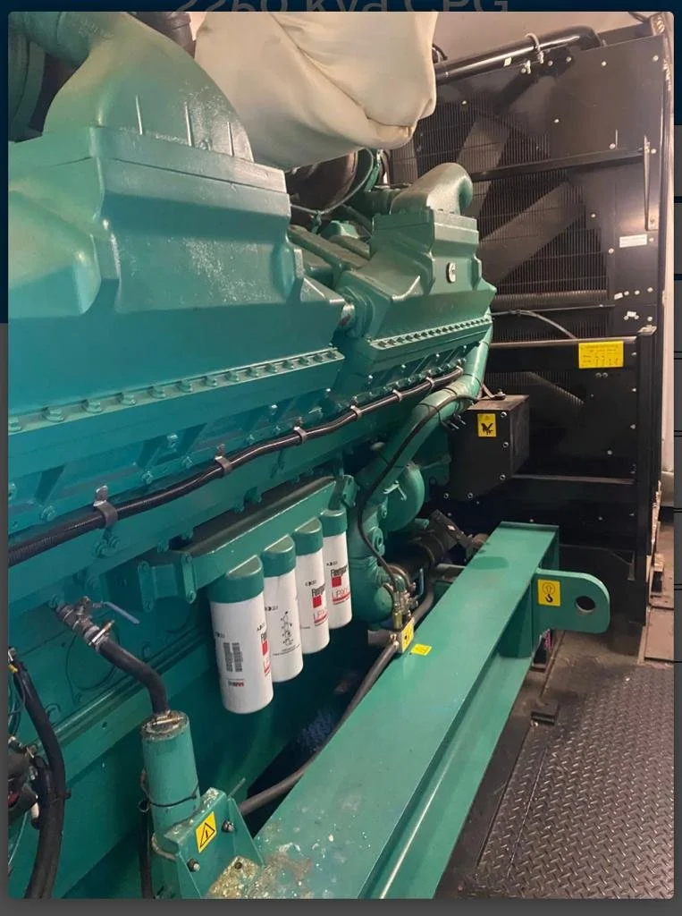 Industrial generator with teal engine components and labeled filters