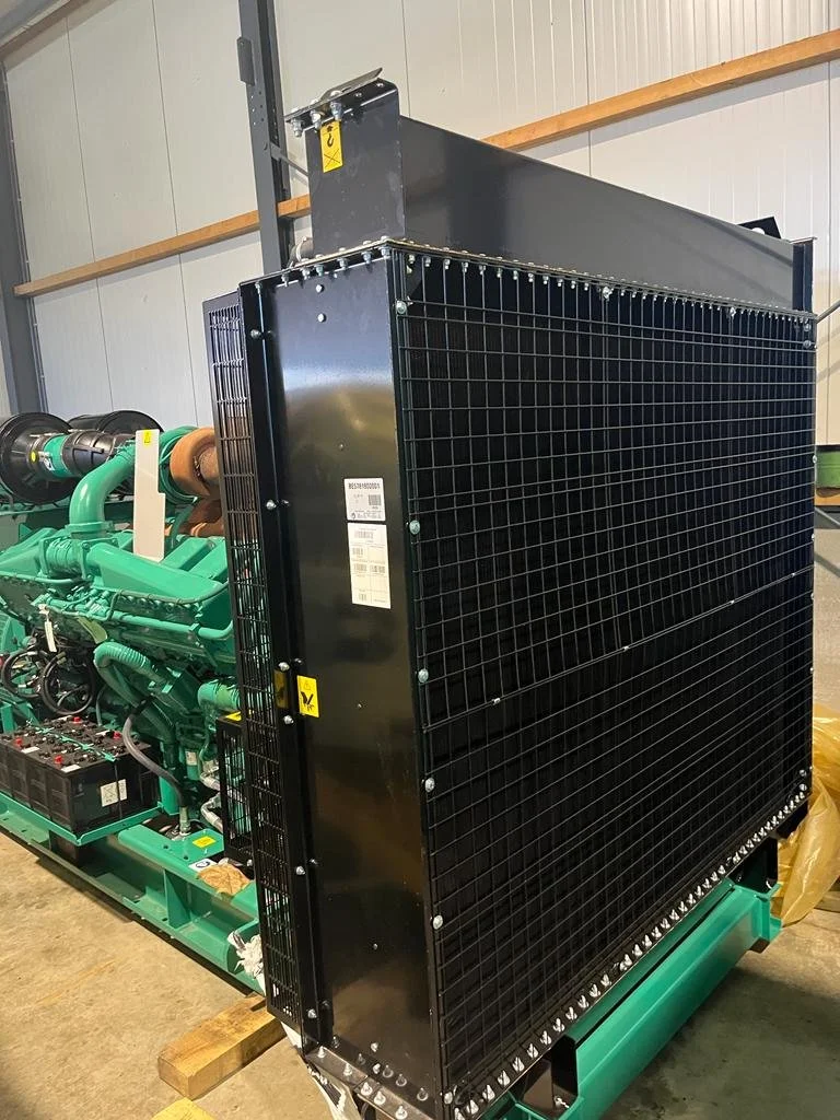 Industrial generator with large black cooling system in a warehouse.