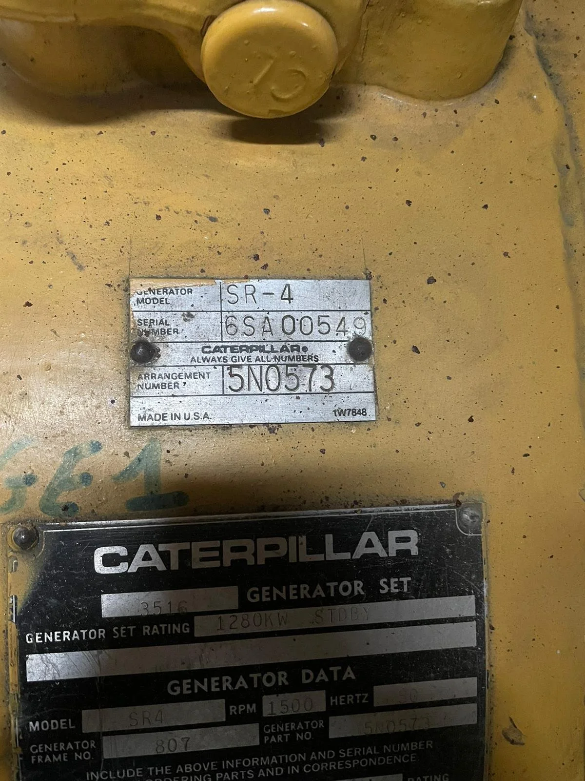 Caterpillar generator identification plates showing model SR-4, serial number 6SA00549, and generator set rating of 1280 kW. The plates list additional data like RPM, Hertz, and part numbers. Made in the USA.