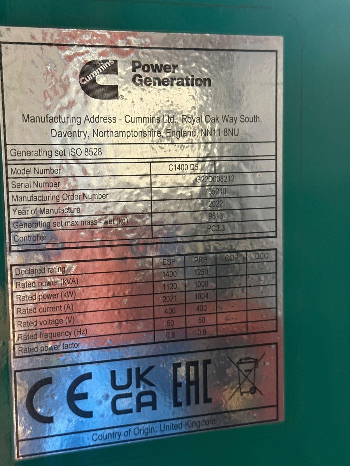 Label on a Cummins power generator showing specifications, model number C1400 D5, manufacturing details, and ratings for power, voltage, frequency, and current. Includes certification marks CE, UK CA, and EAC.