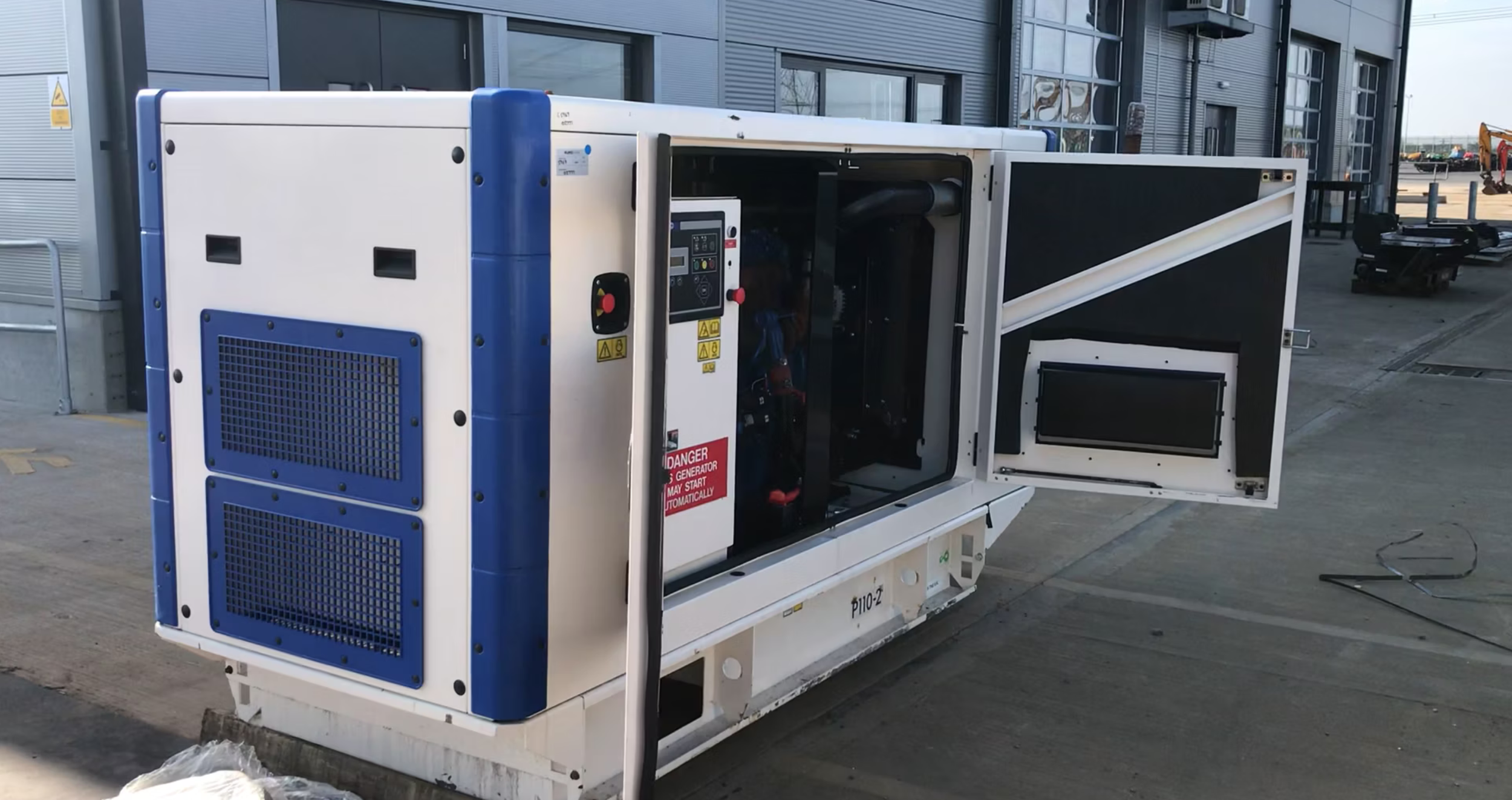 Industrial diesel generator with open panels outdoors
