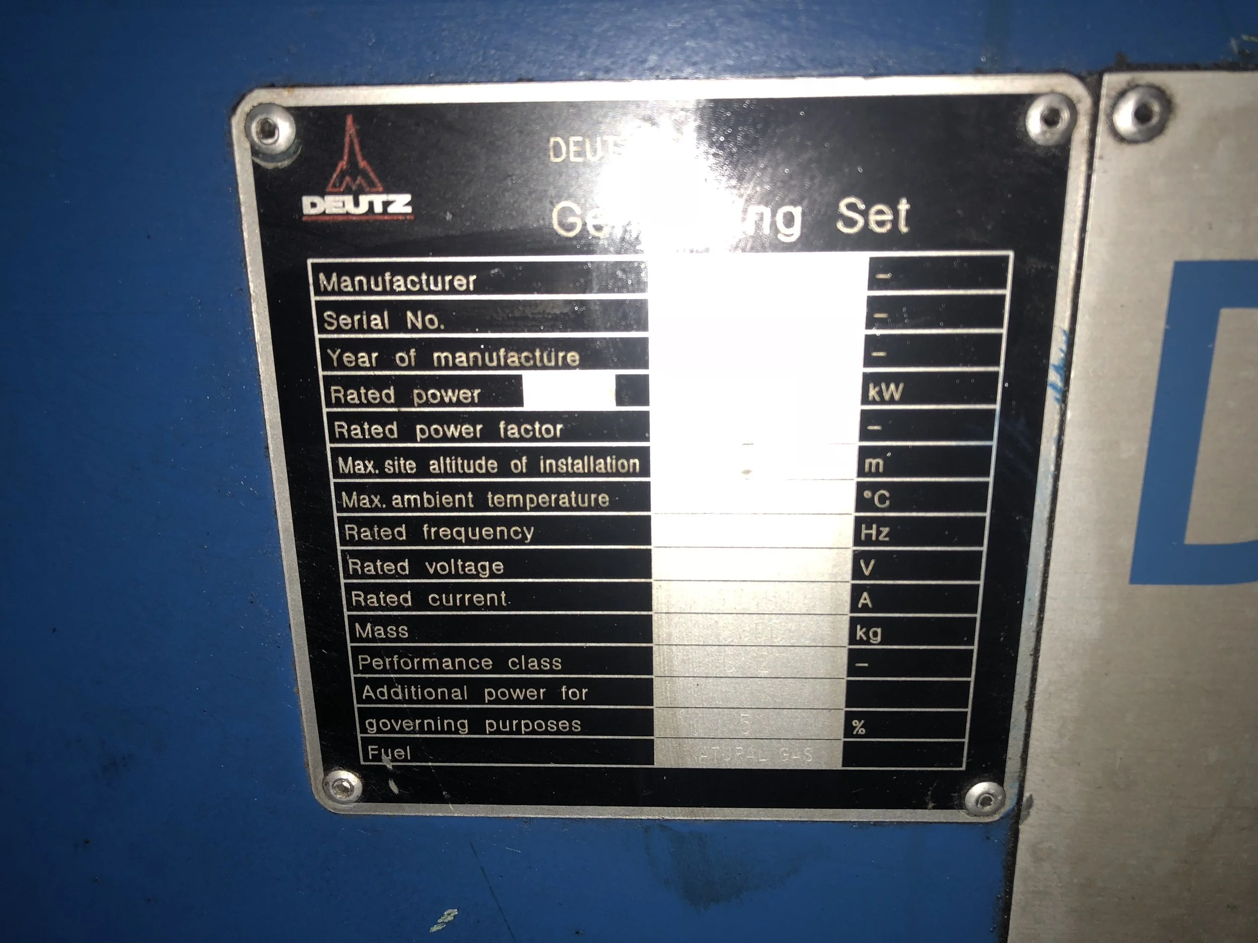 Close-up of a Deutz generator information plate displaying specifications such as manufacturer, serial number, year of manufacture, rated power, frequency, voltage, current, and type of fuel (natural gas).
