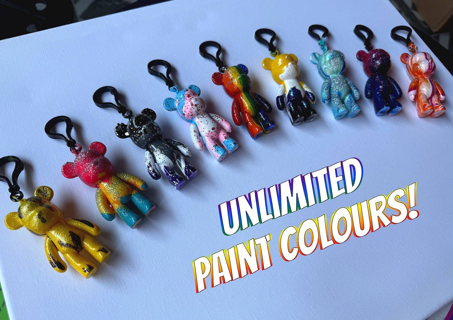 Image showing rainbow coloured bear keyrings spread over white canvas with text saying 'unlimited paint colours!'