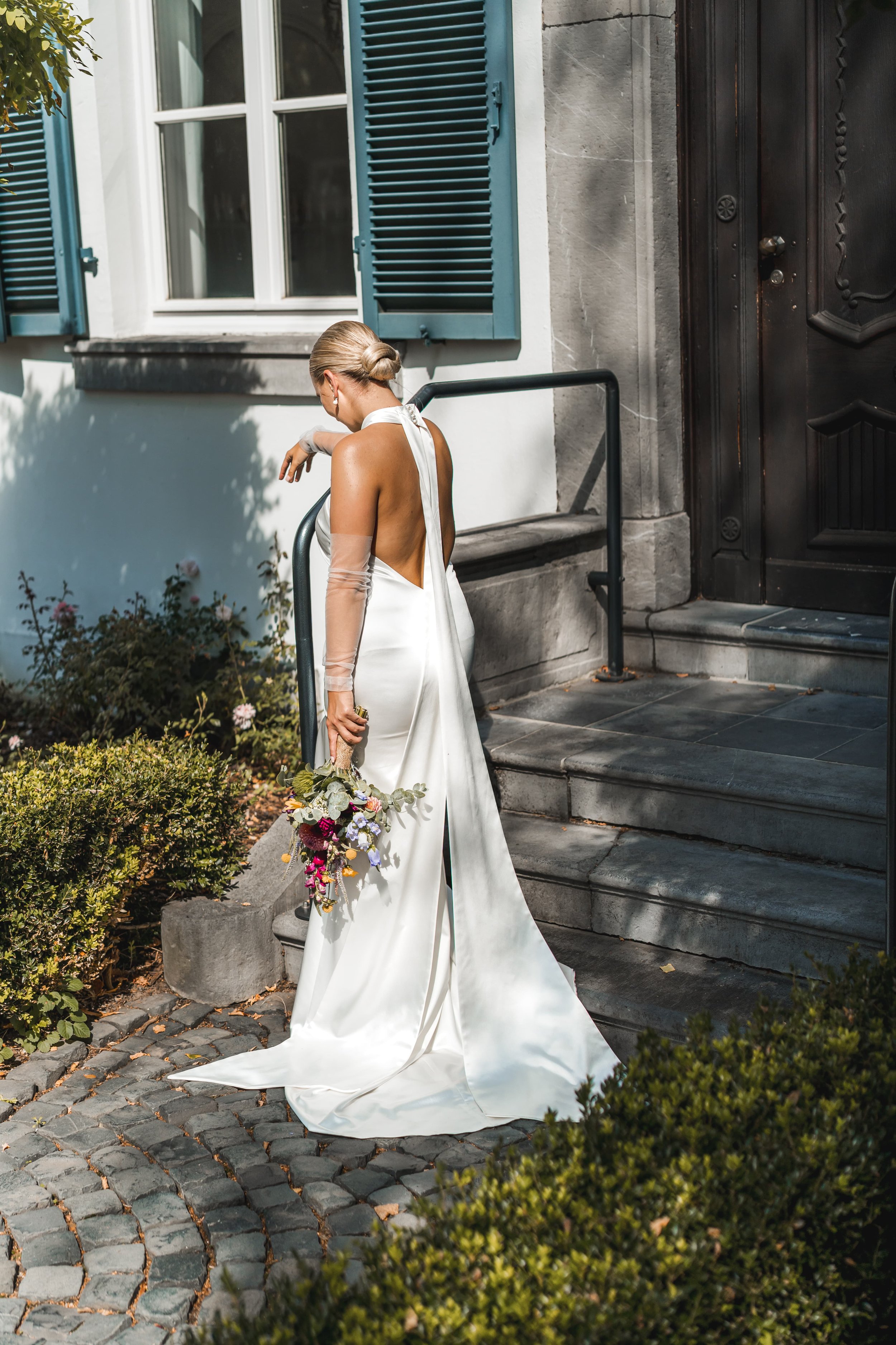 Foto einer Braut an ihrem Hochzeitstag mit ihrem Brautstraß in einem weißen Kleid