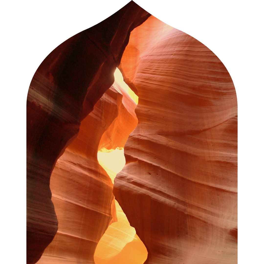 Narrow slot canyon with smooth, layered sandstone walls illuminated by sunlight.