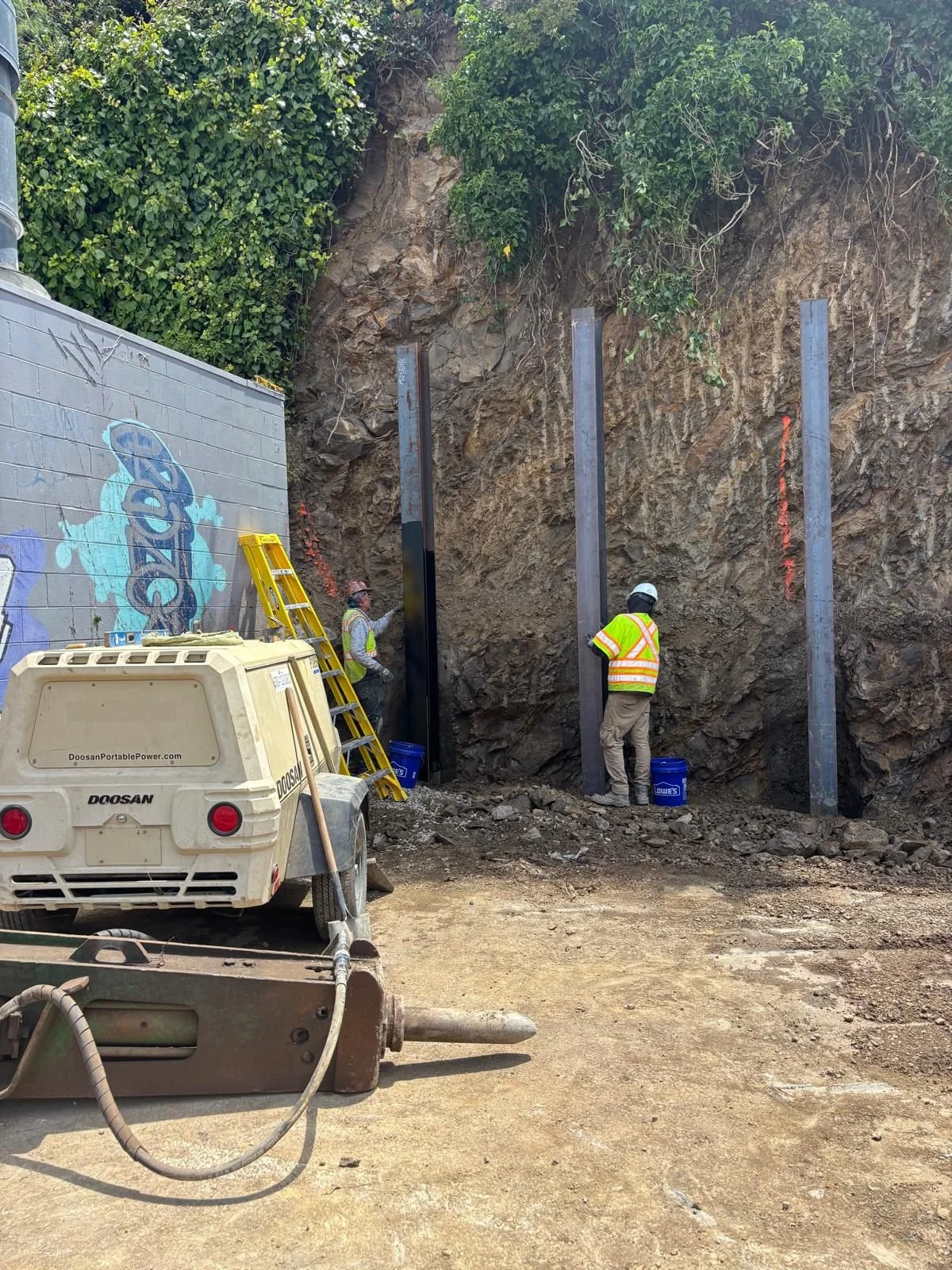 Application of protective paint on beams to prevent corrosion and aid heat absorption.