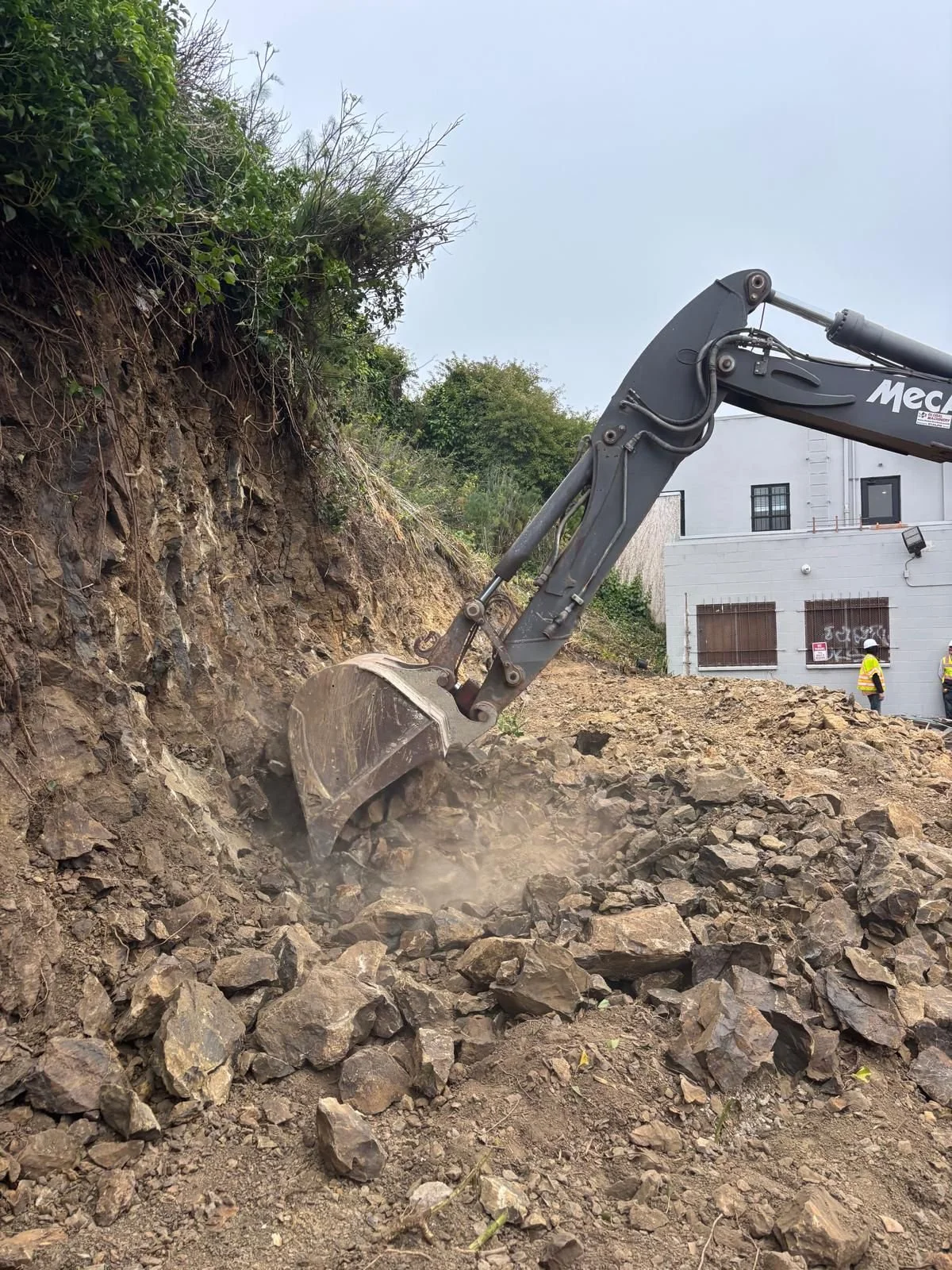 Excavation in progress to create space for retaining wall installation.