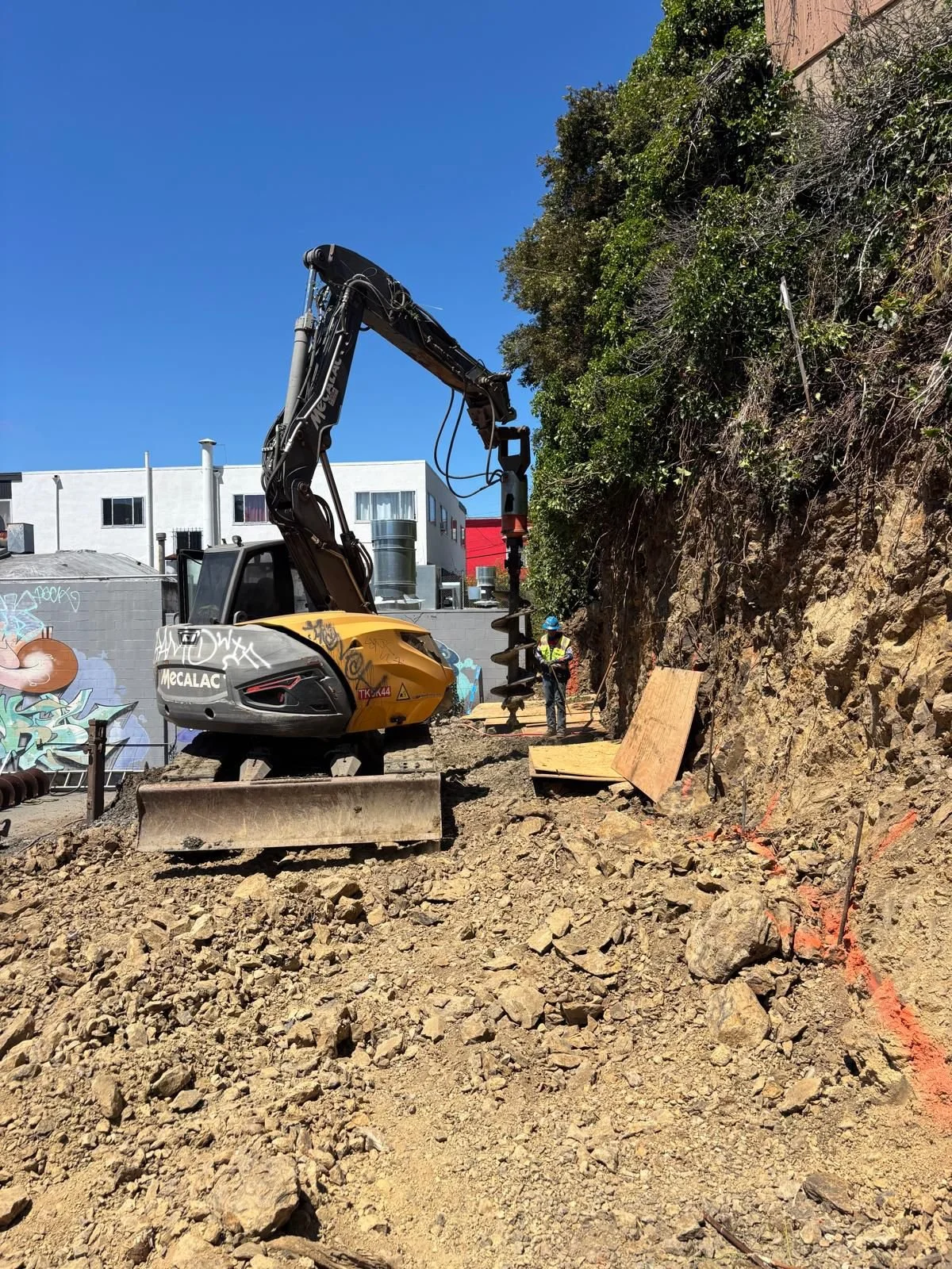 Drilling operations underway to create holes for beam installation.