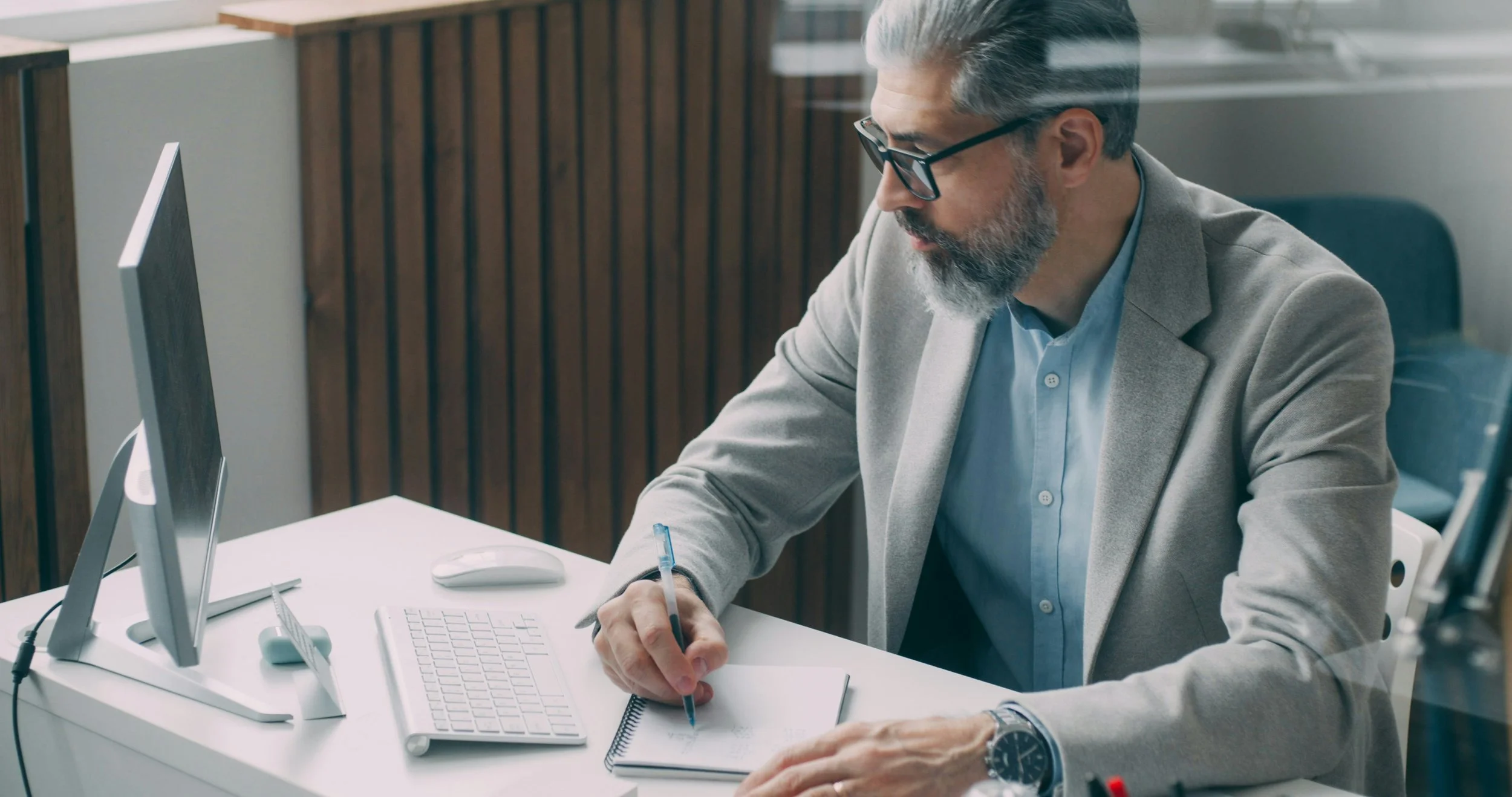 Property manager reviewing documents at a desk using technology in a New Jersey office setting