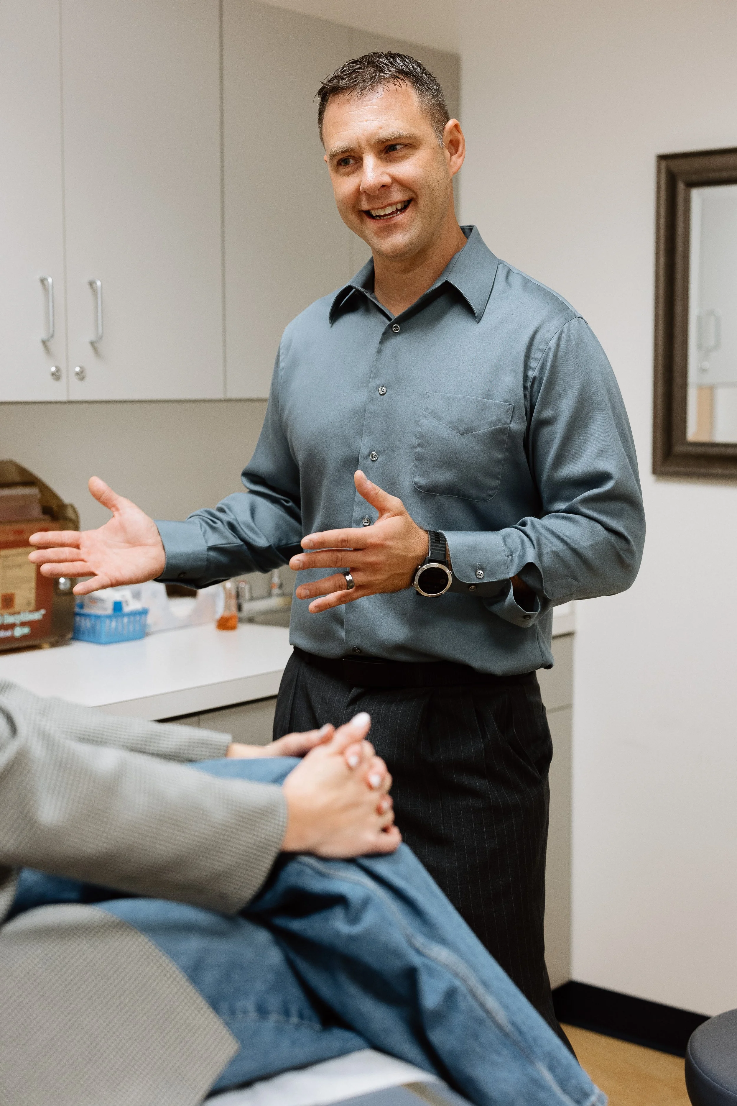 Dr. Opris stands in an exam room talking with a patient