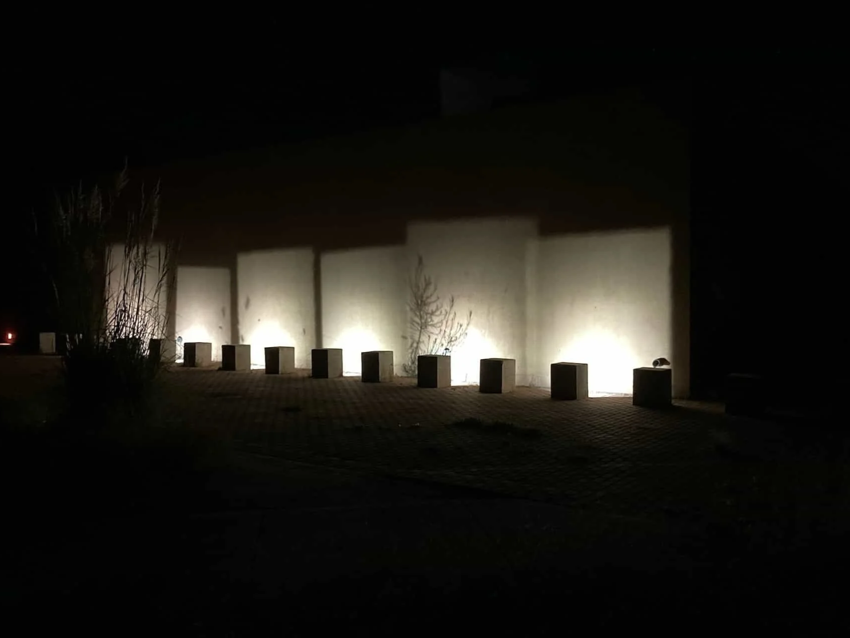 ProjectingREVOLUTION!, 2022. Laser cut black coroplast panels, existing light fixtures in concrete bollards. 18 x 36” each (set of 6).