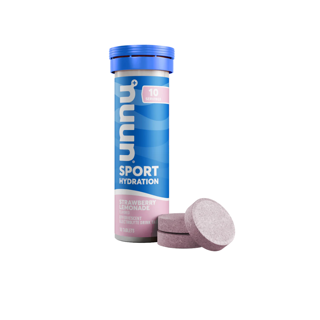 A tube of Nuun Sport Hydration Strawberry Lemonade flavored electrolyte tablets with three purple tablets placed in front.