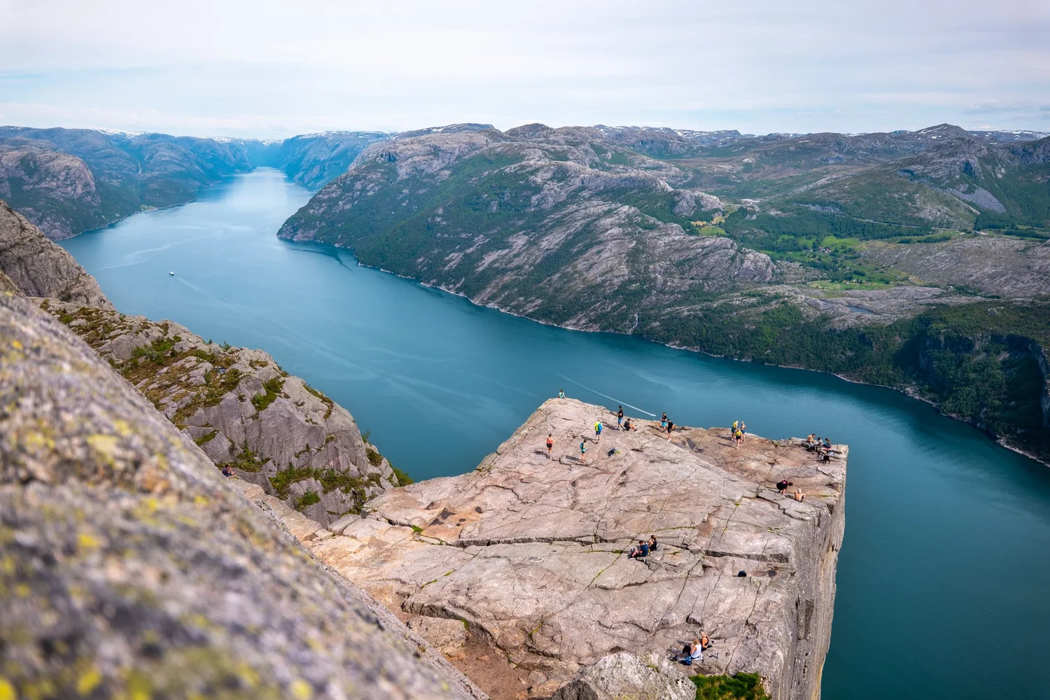 Aerial view of the Preikestolen cliff platform with walkers standing high above Lysefjord