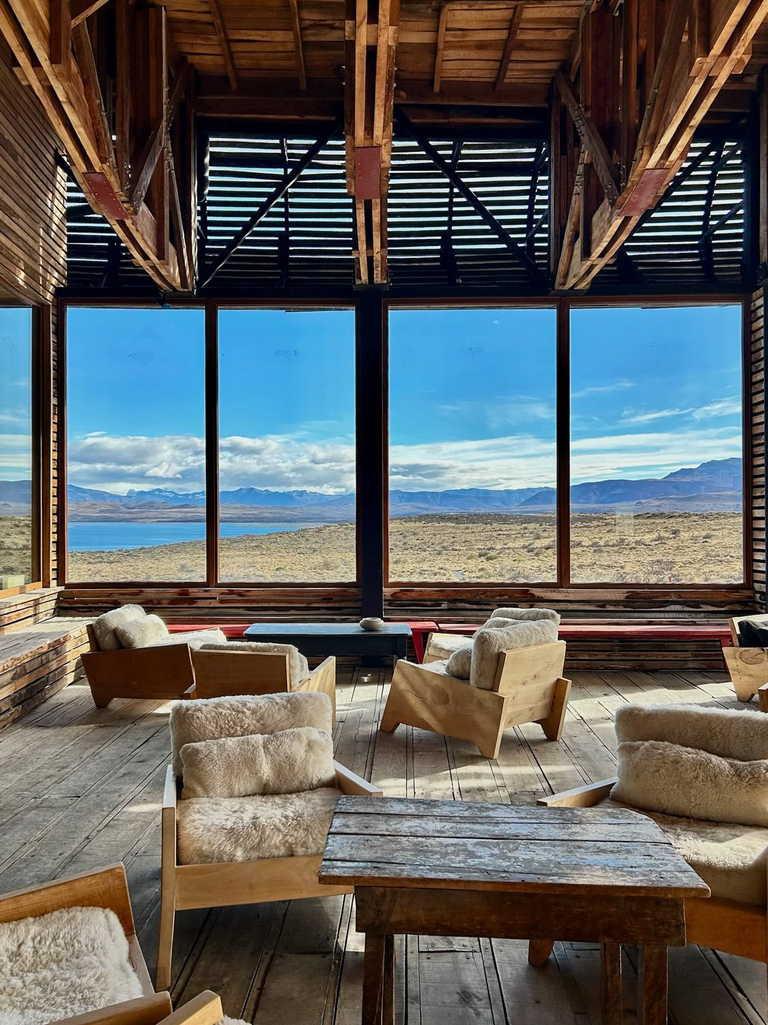 A communal lounge at Tierra Patagonia where travellers gather to share stories over the lake and mountains