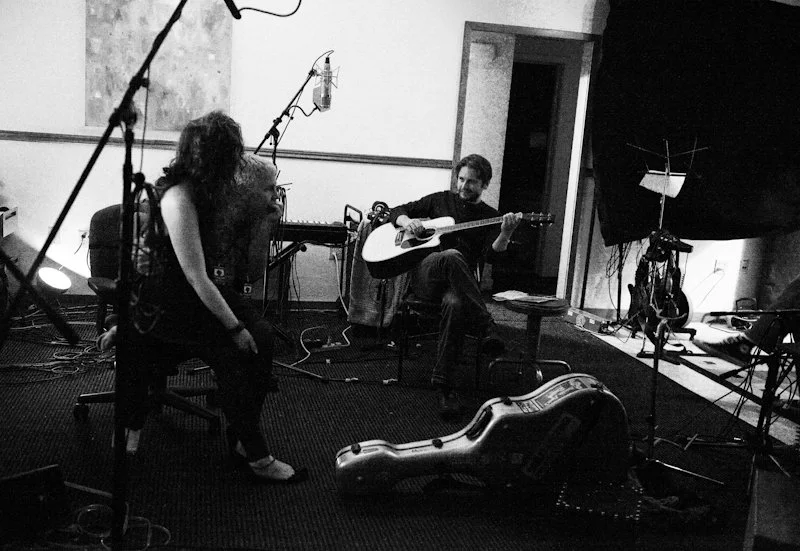 Two men and one woman taking a break in a recording studio