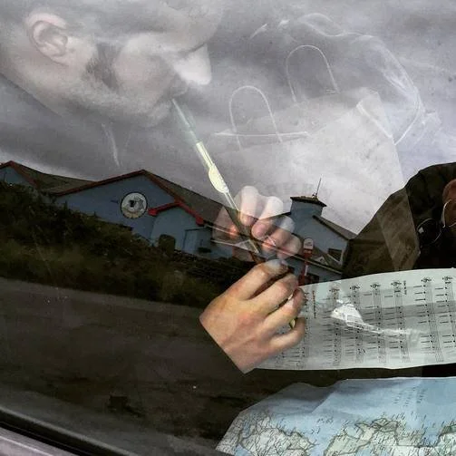 Man playing tin flute in car in Ireland
