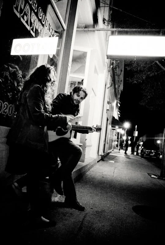 Man and woman playing music outside a music venue