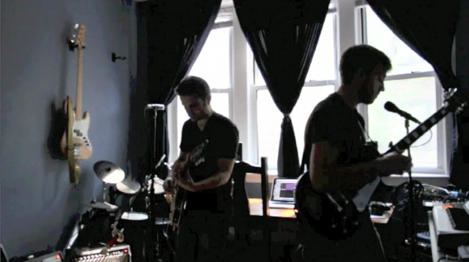 Two men performing music in an apartment