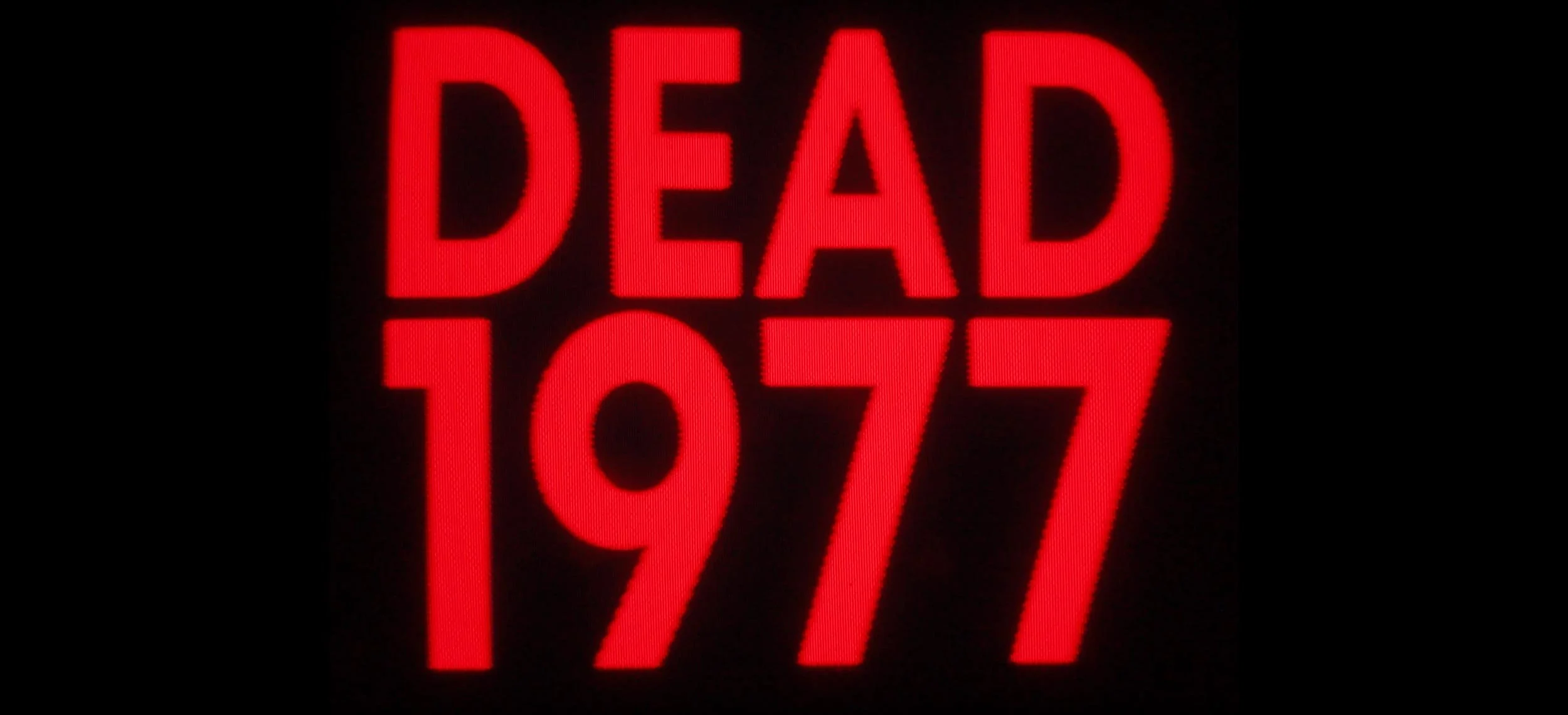 Bright red illuminated digital sign displaying the word 'DEAD' above the numbers 1917 on a black background.