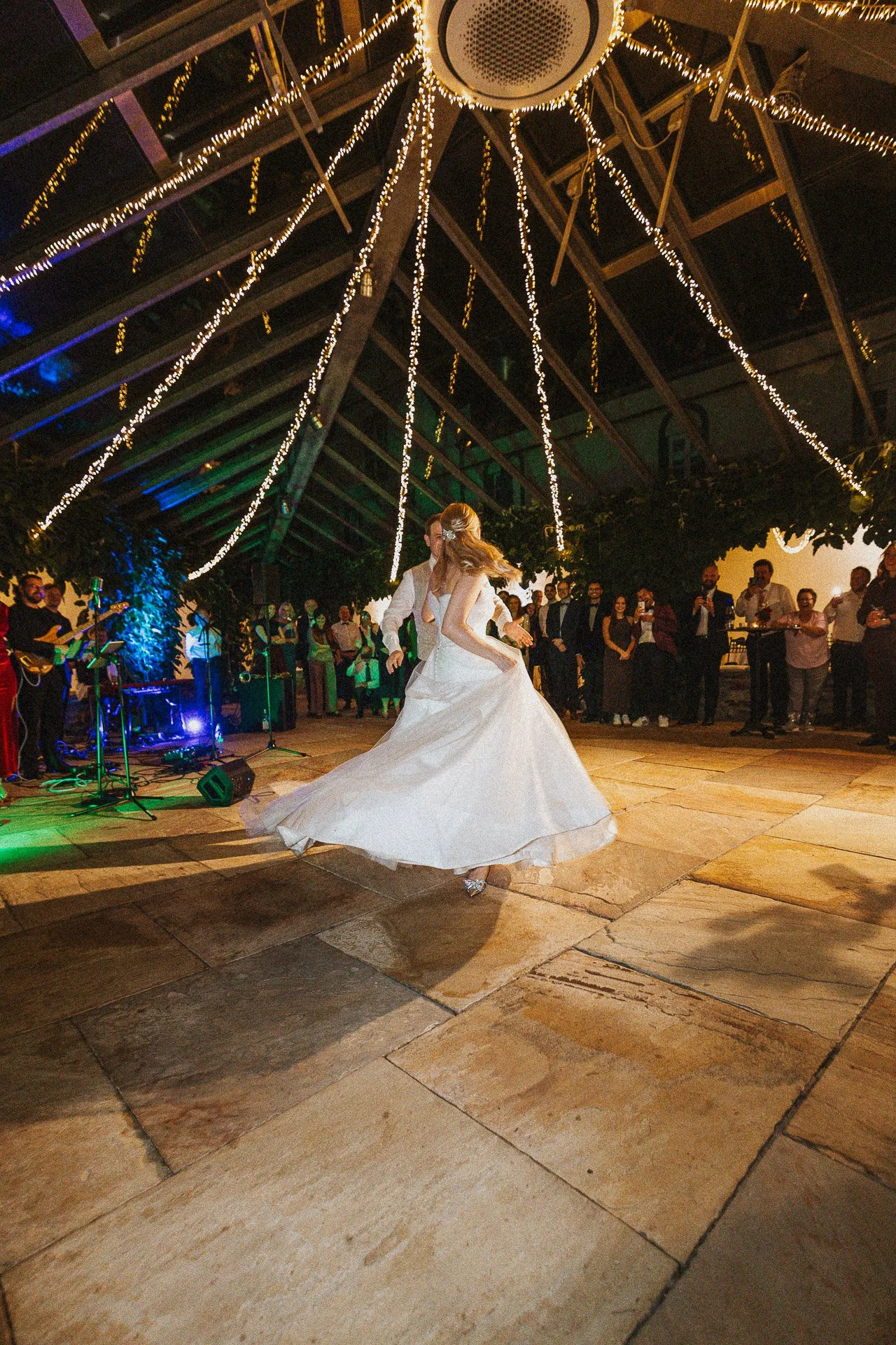 Die Braut Elisabeth in einem lebendigen Moment während des Hochzeitstanzes am Abend.
